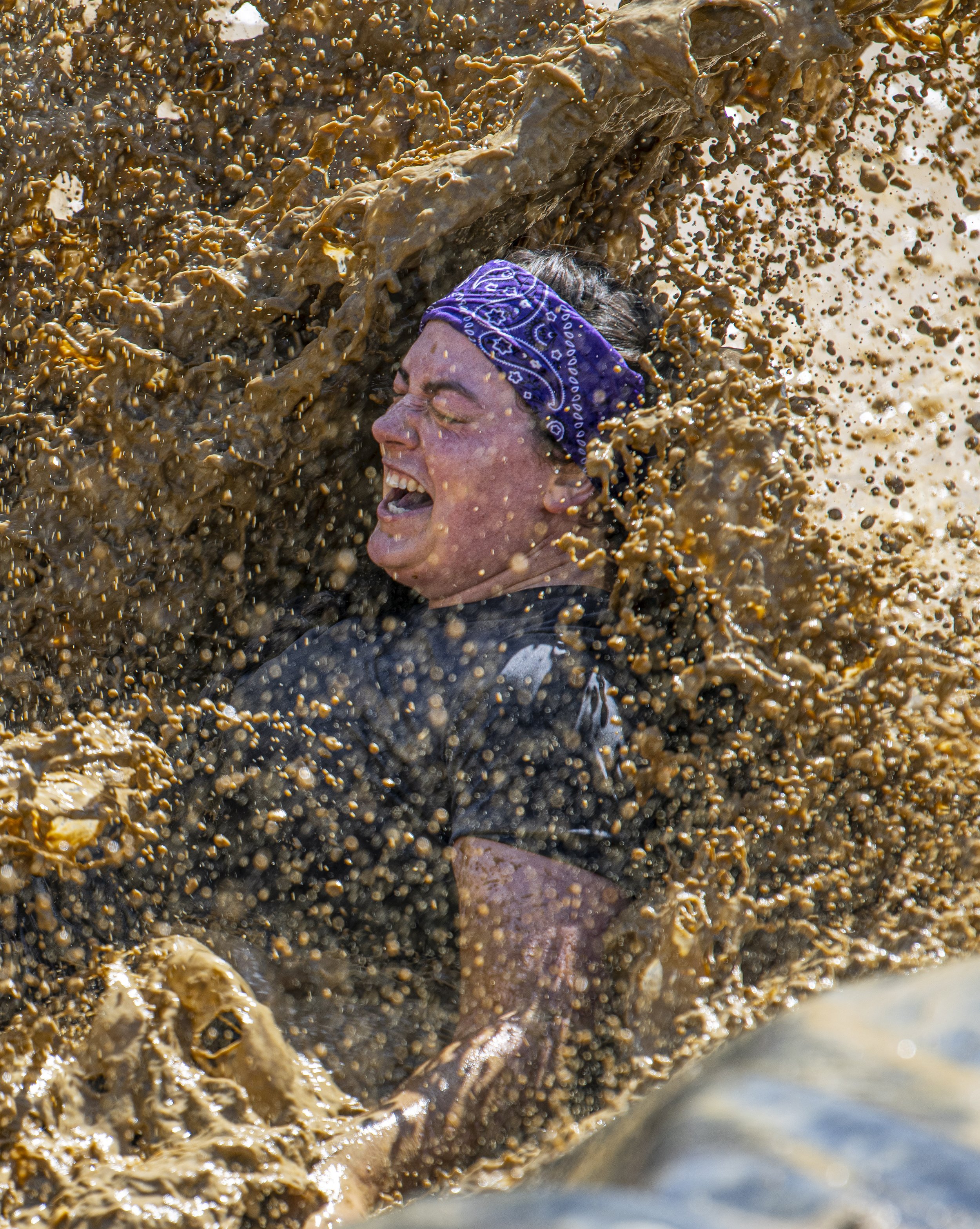  A Tough Mudder Competitor crashes into the Muddy water at the mud slide portion of the course at the Tough Mudder event held in San Bernadino on April 9, 2022. (Jon Putman | The Corsair) 