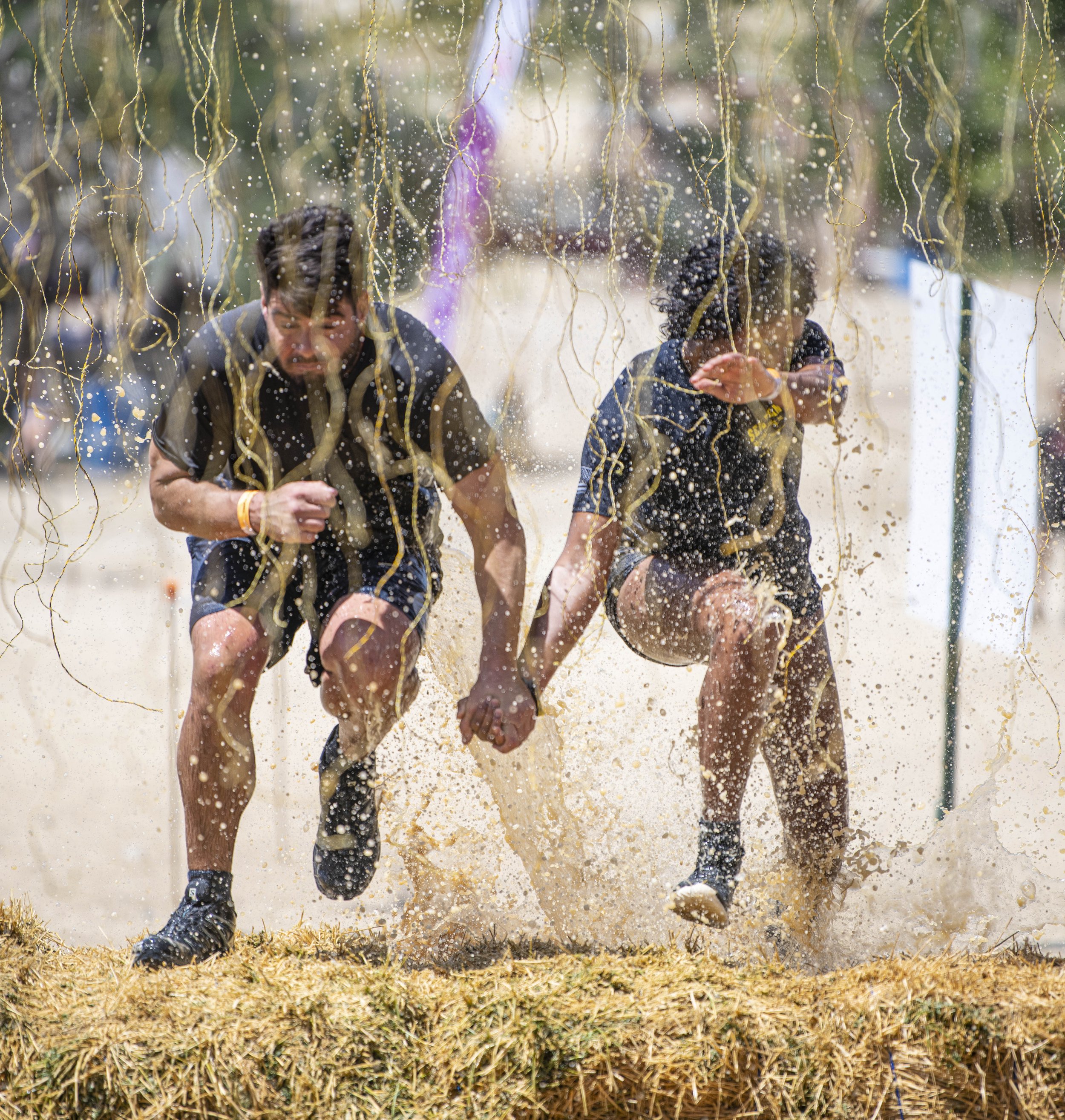  A couple of Tough Mudder Competitors make their way the shock wire pit as they hold hands at the Tough Mudder event held in San Bernadino on April 9, 2022. (Jon Putman | The Corsair) 