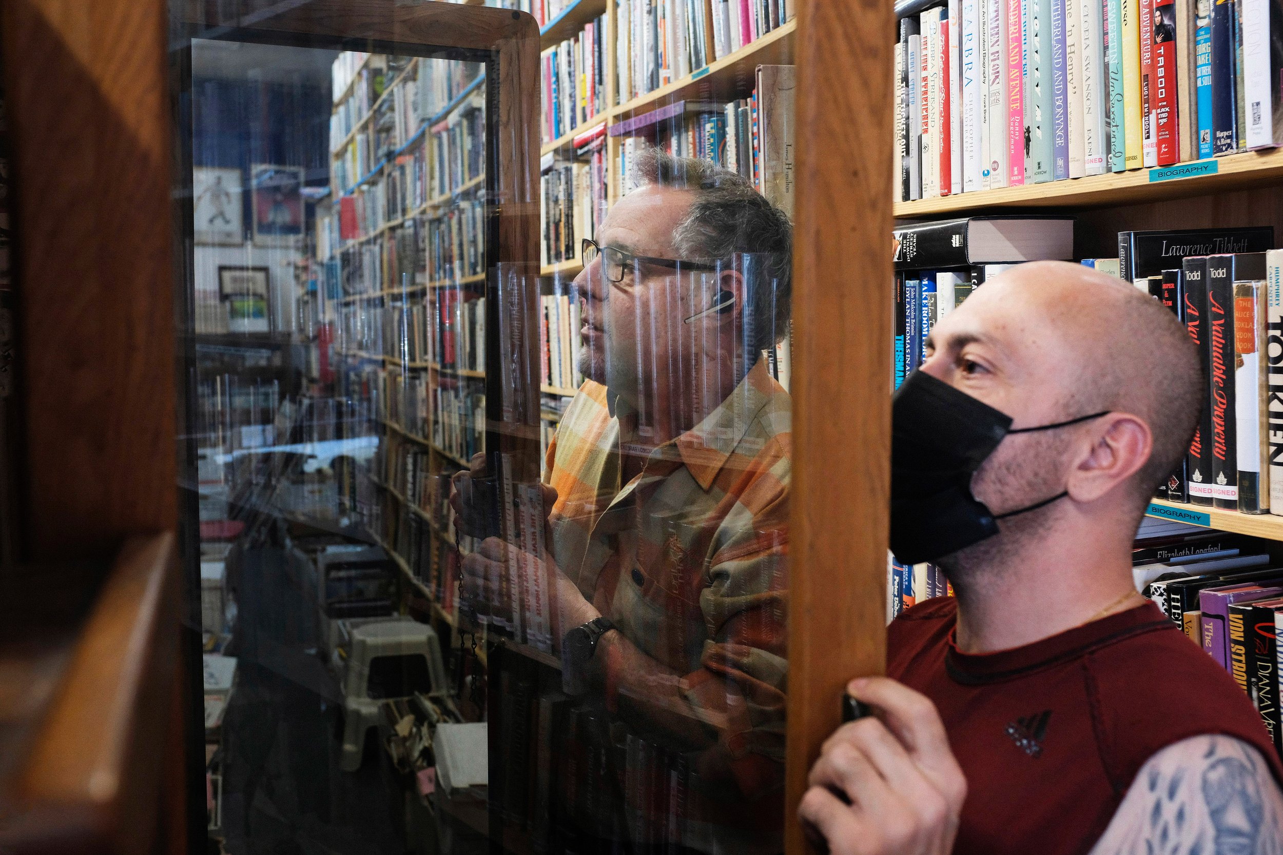  David Kaye (left) opens another locked book case for Reza Asgari (cq) (right), who asks about signed books of actor autobiographies. Asgari visits the store alone, since he is looking for a gift for his girlfriend. David Kaye Bookstore and Memorabil