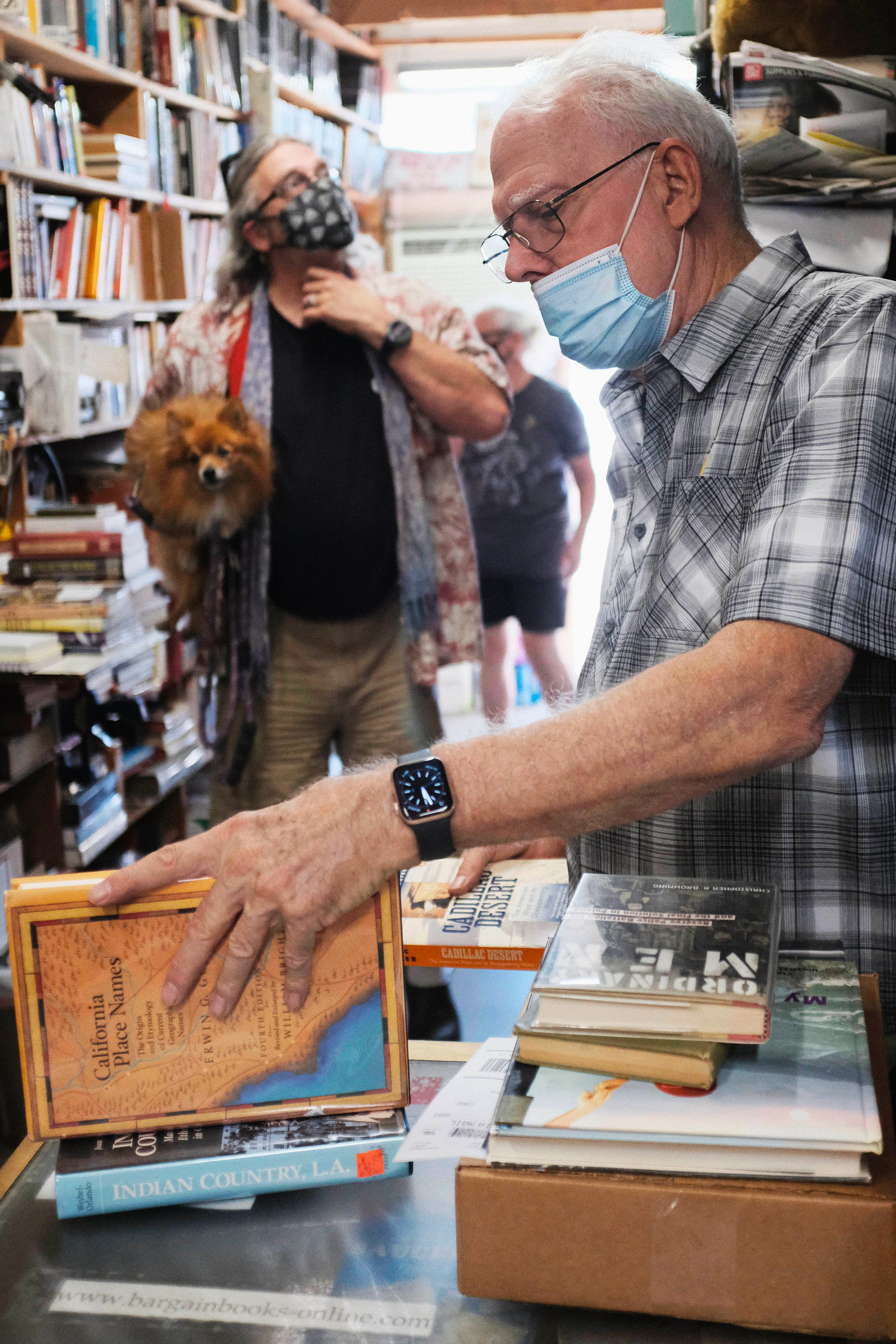  Bill Wirt checks prices on books as he checks out a customer. Heavy foot traffic comes from the back entrance of the store, as on Saturday’s they open the back door for a $1 book section, at Bargain Books in Van Nuys, California. Saturday, October 2