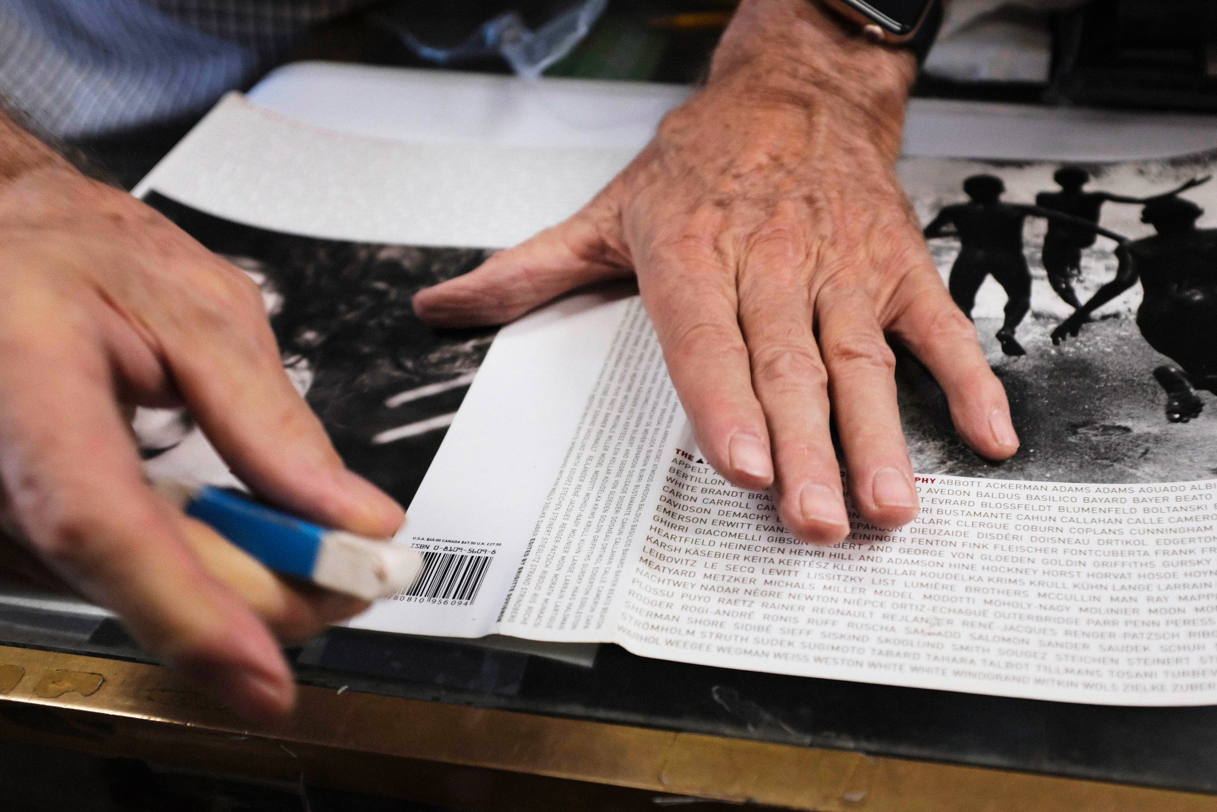  Following his treatment of oil, Bill Wurt uses an eraser to get out tougher spots of dirt on book covers before covering them in a new dust jacket. Wurt explains that some spots will smear if using just a wet cloth to remove, which is why he is usin