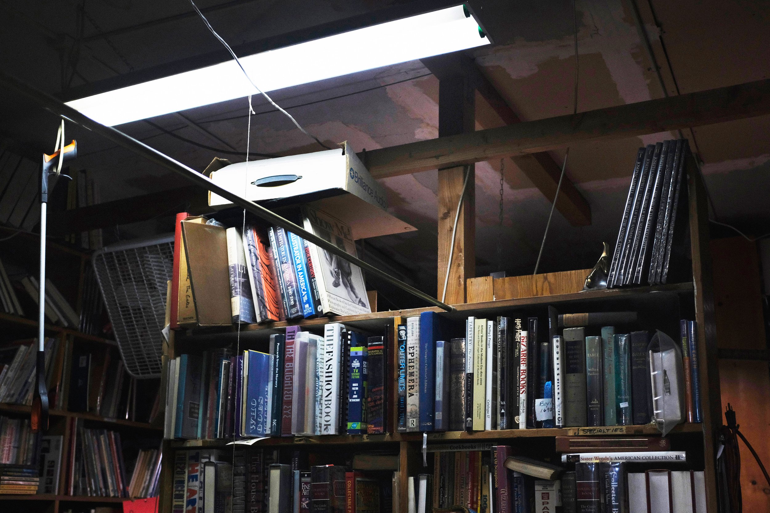  A fluorescent light shines down onto a shelveed section of rare books in the back of Bargain Books in Van Nuys, Los Angeles California on October 15, 2022 (Anna Sophia Moltke | The Corsair) 