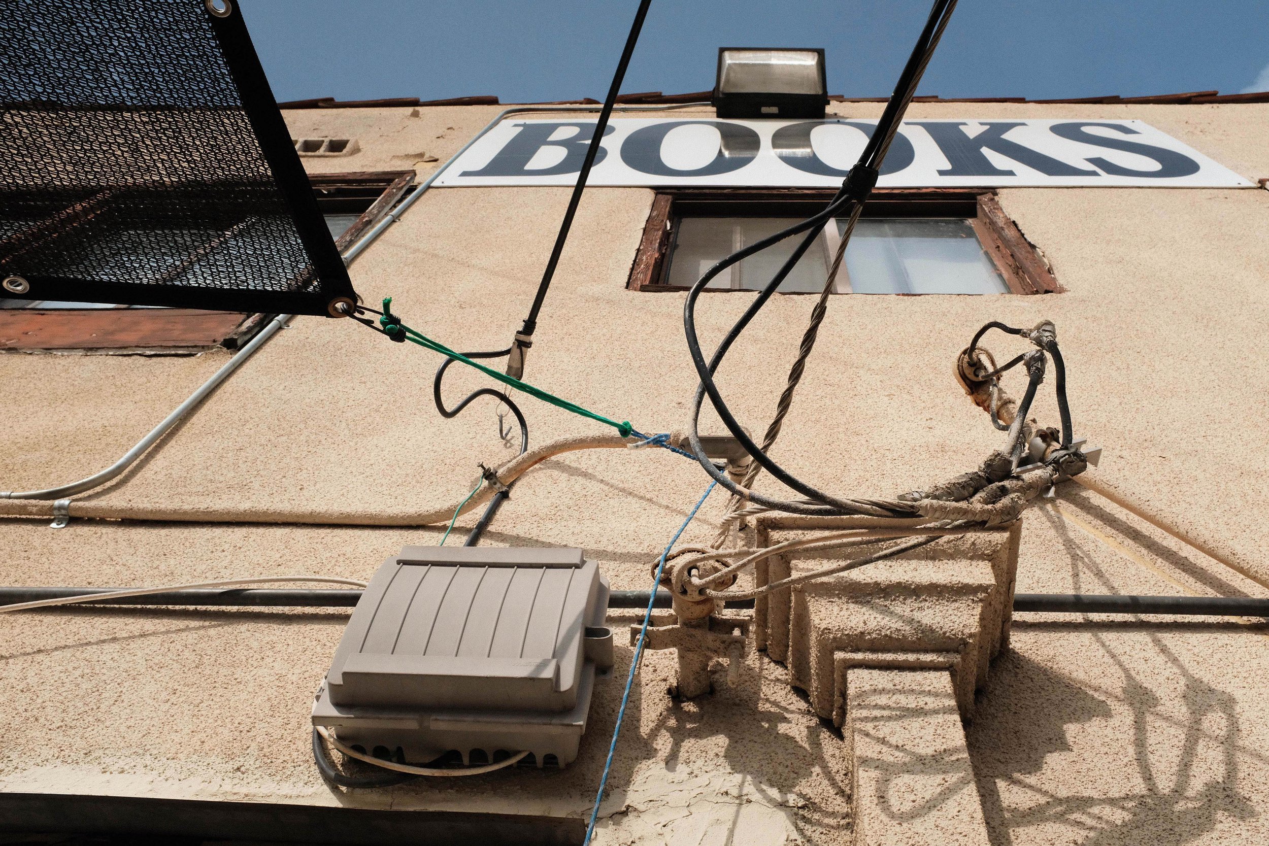  Outside of the back entrance hangs a 'Books' sign above wires, strings, and cables. Bargain Books in Van Nuys, Los Angeles, California on Friday November 19, 2021. (Anna Sophia Moltke | The Corsair)) 