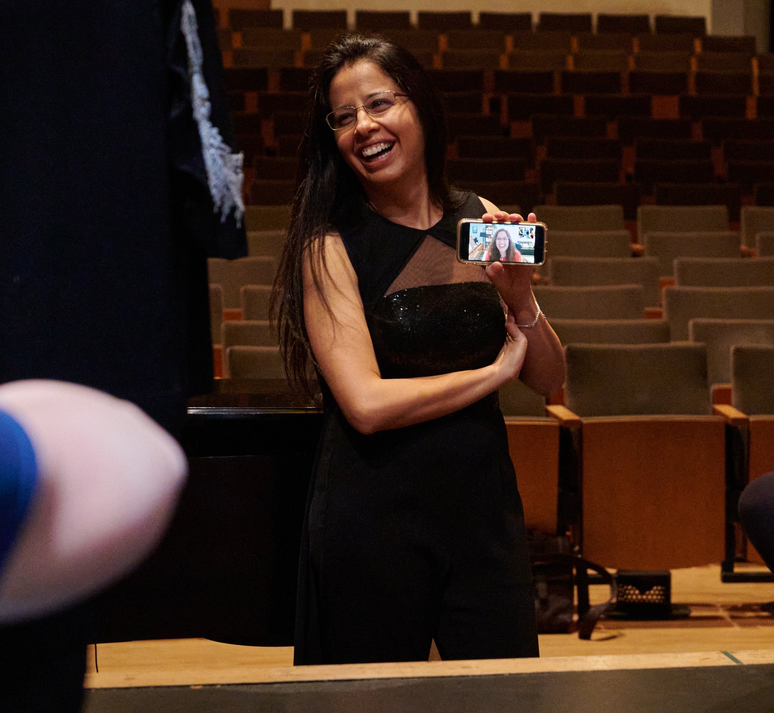  Music Director Mercedes Juan Musotto holds a phone with Director Janelle DeStefano connected on Zoom, so that Dr. DeStefano can talk to the cast on opening night of the Santa Monica College Opera Theatre production of "Die Fledermaus" at The Broad S