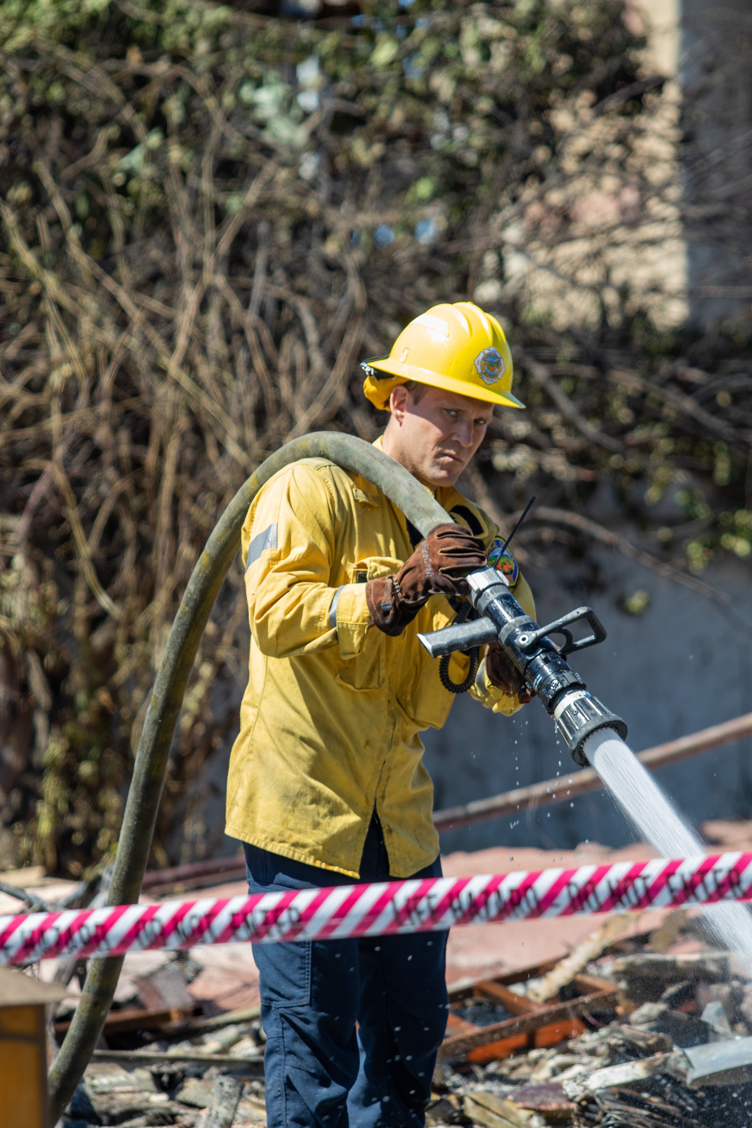  Orange County Firefighter spraying down at the rubble to mitigate hotspots on Fri. May 13, 2022 at Laguna Niguel, Calif. (Danilo Perez | The Corsair) 