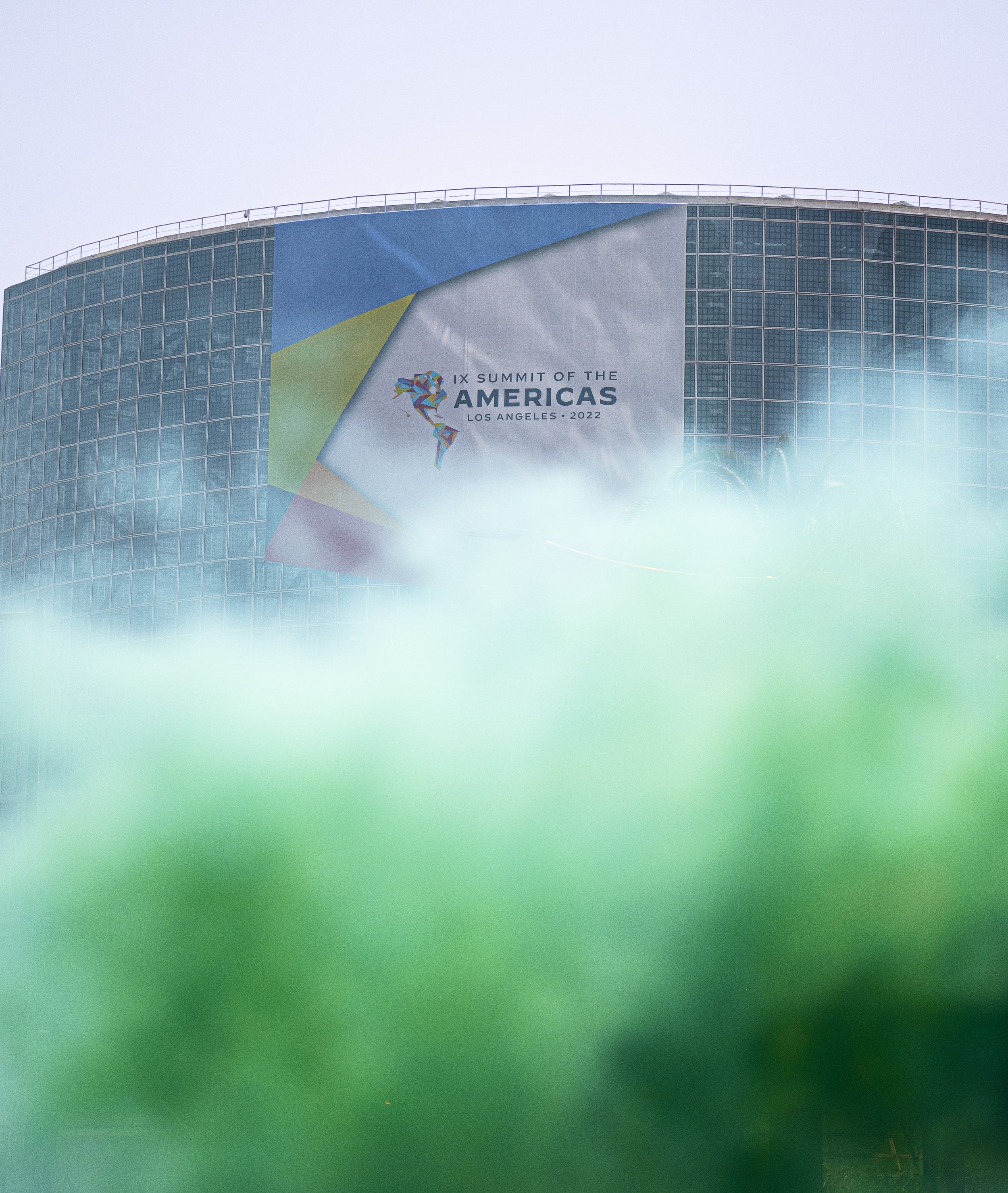  A cloud of green smoke rises under the Summit of Americas banner being held at the Convetion center in downtown Los Angeles. (Jon Putman | The Corsair) 