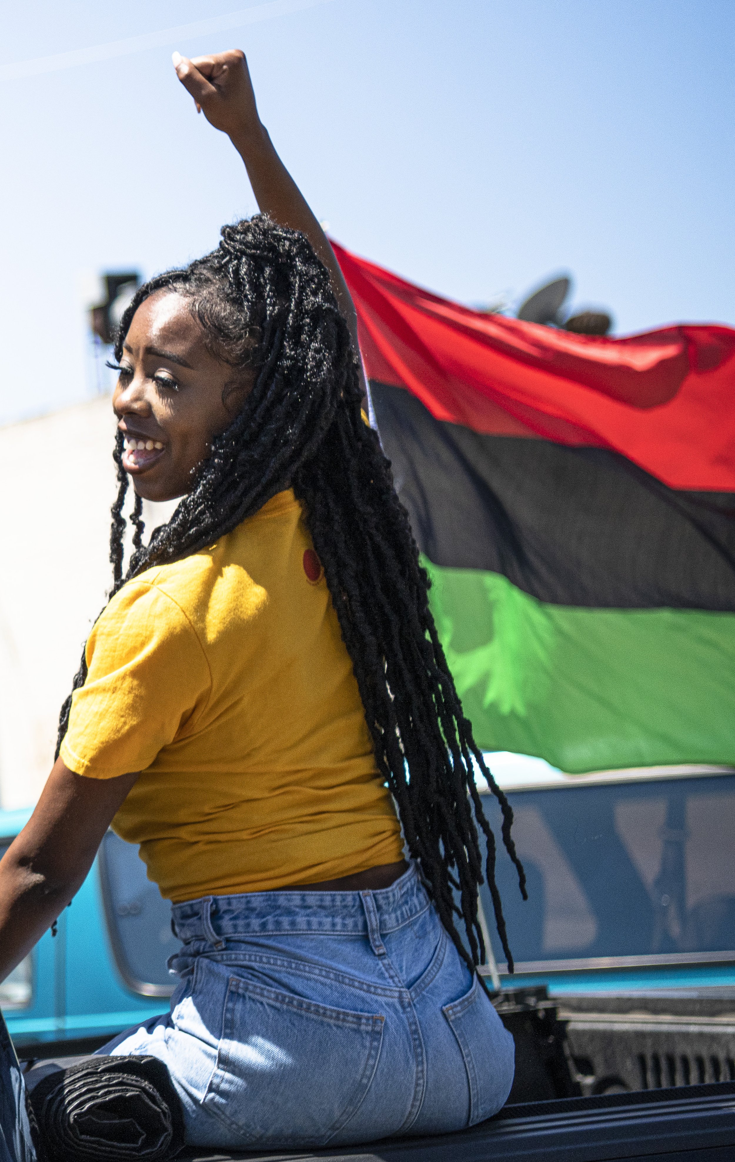  A women holding a fist up showing support for Juneteenth passes by as the parade makes its way down the designated route. (Jon Putman | The Corsair) 