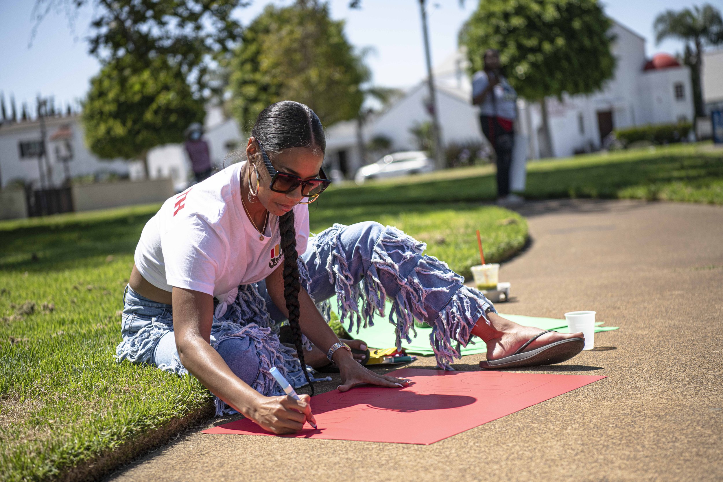  A participant in the Juneteenth parade decorates a sign that will be displayed on her jeep (Jon Putman | The Corsair) 
