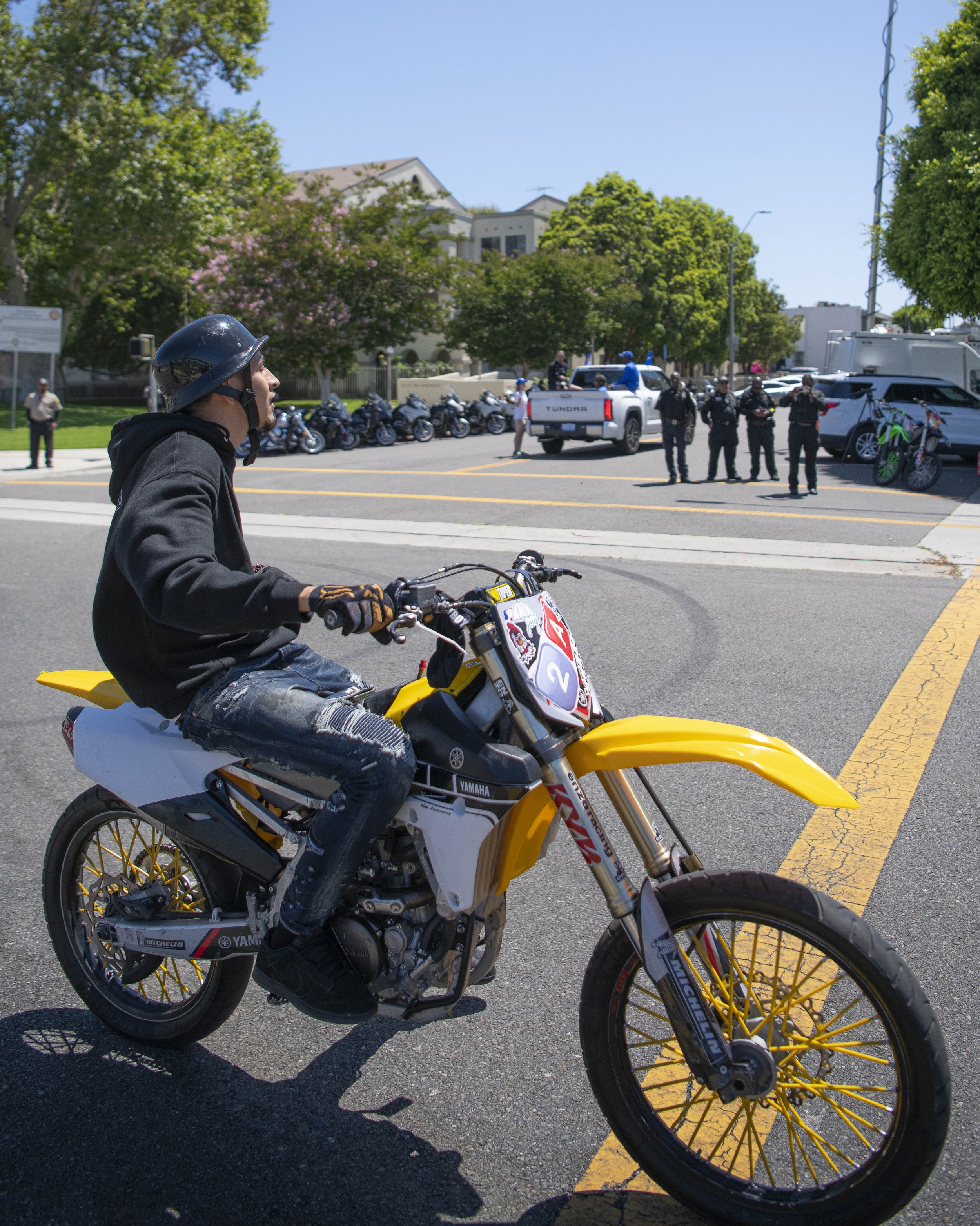  A mototocycle rider participating in the Juneteenth parade rides by as police watch and even snap some photos.  (Jon Putman | The Corsair) 