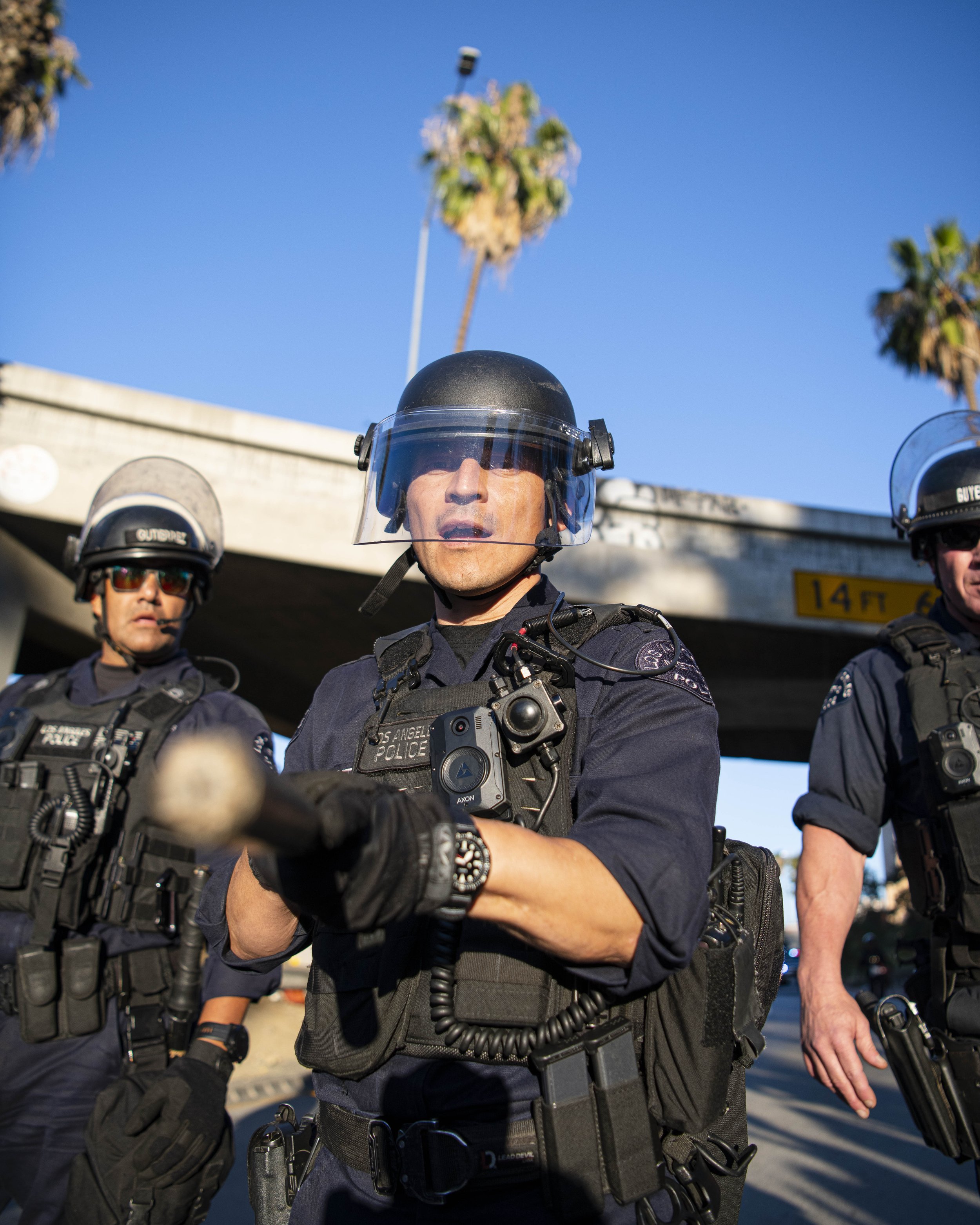  A LAPD officer yells to press to back up before he swings as they force protestors off of the 110 Freeway. (Jon Putman | The Corsair) 