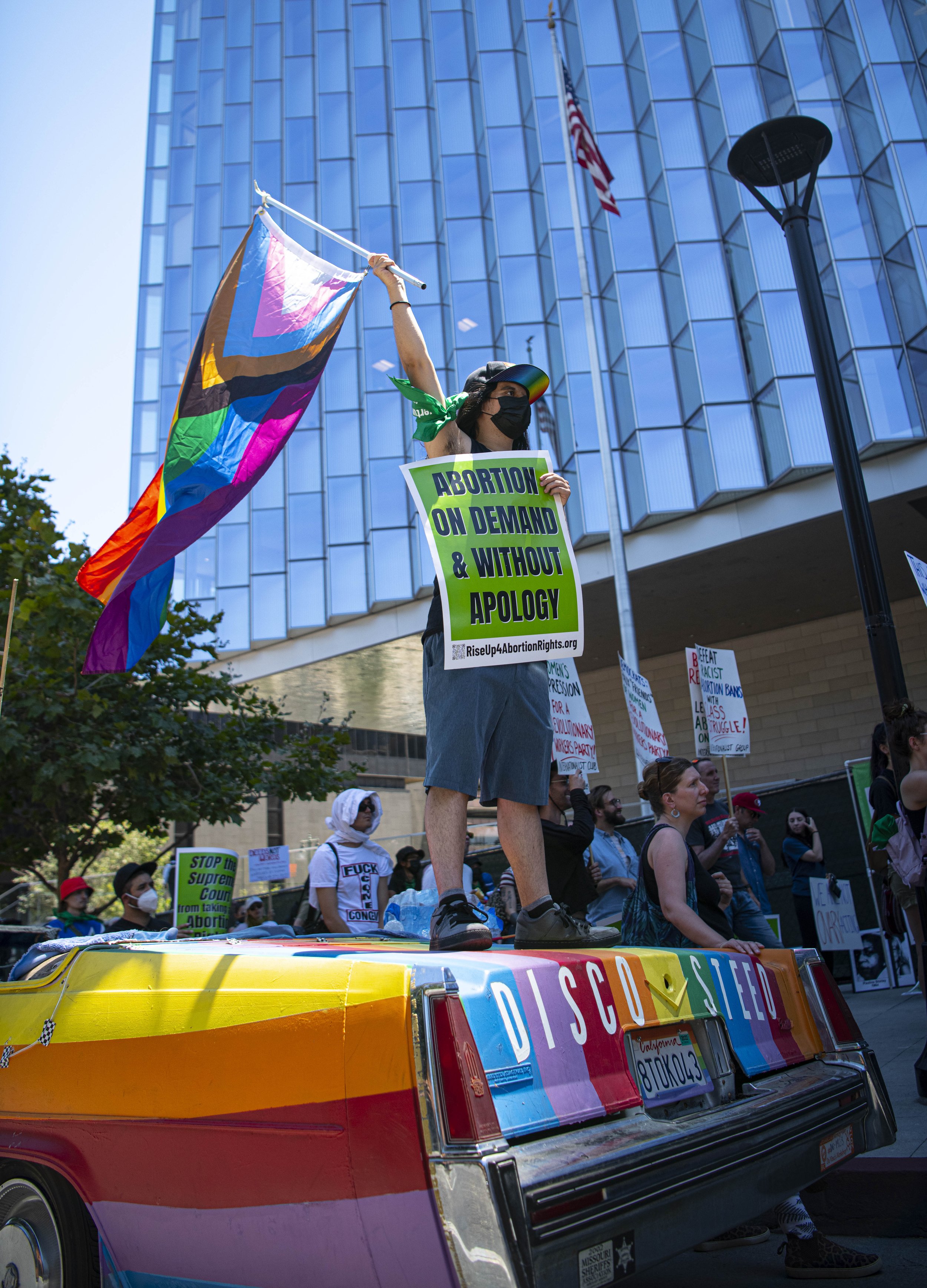  An abortion rights supporter waves a rainbow flag on top of a rainbow car to show the LGBTQ+ community has their support. (Jon Putman | The Corsair) 