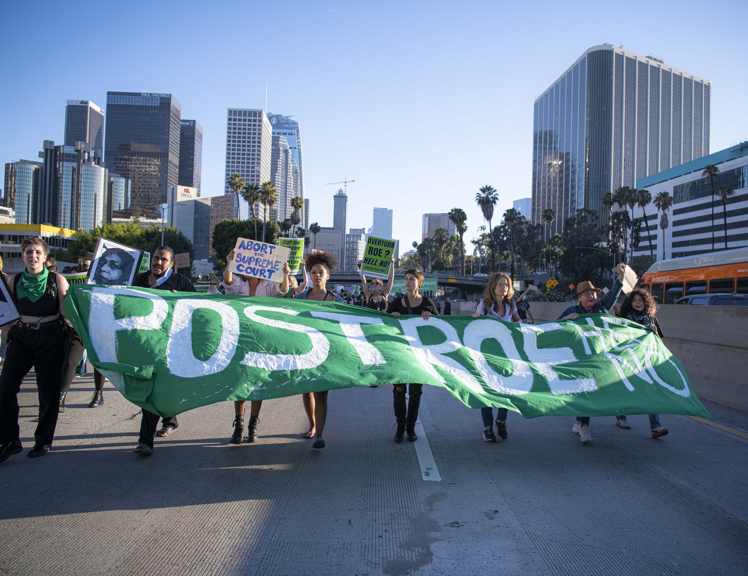  Abortion rights protestors hold a large "Post Roe Hell No" banner as they march two lanes wide down the 110 Freeway downtown Los Angeles. (Jon Putman | The Corsair) 