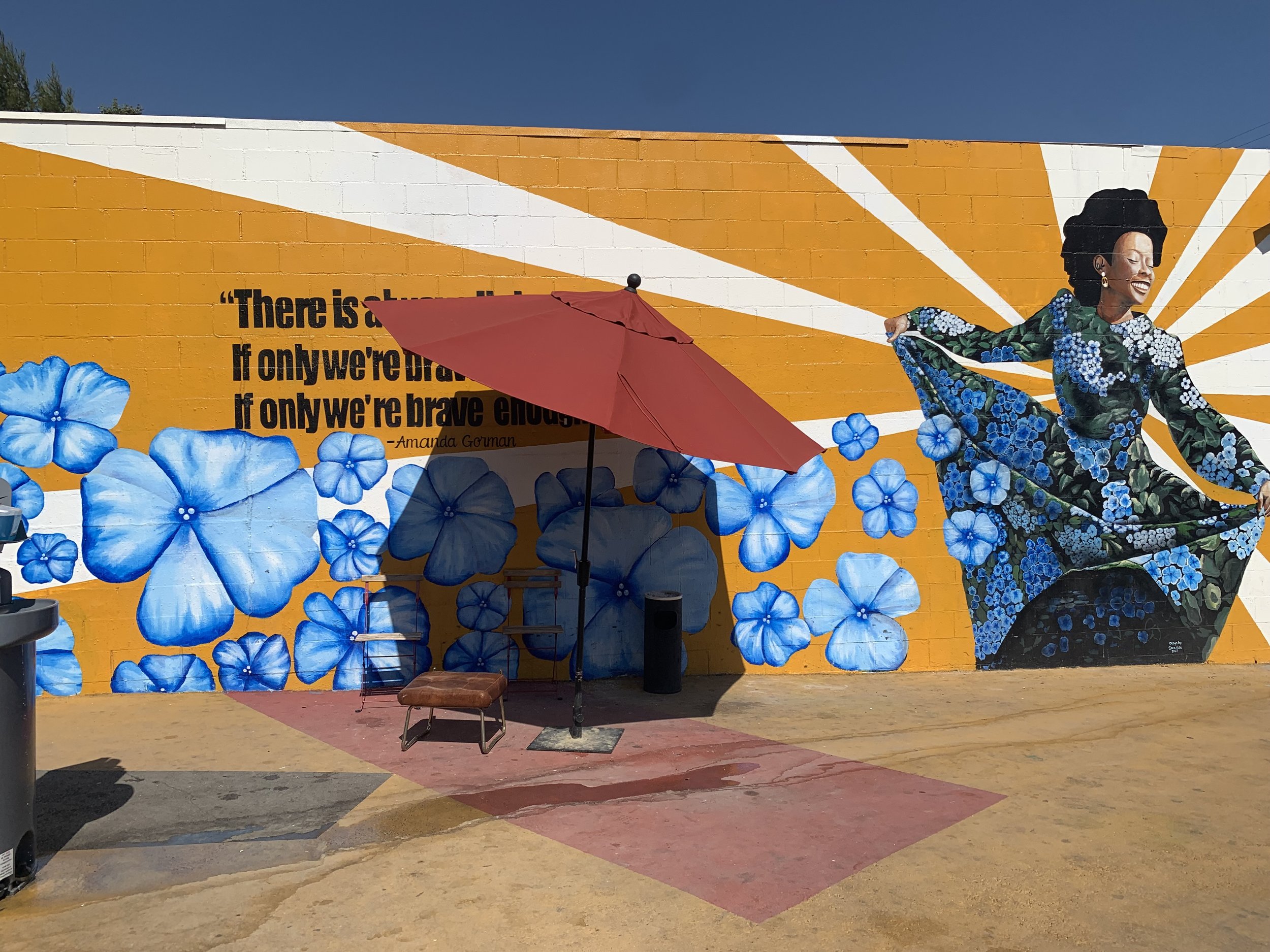  A sitting area in front of a mural with a quote from poet Amanda Gorman which reads "There is always light, if only we're brave enough to see it. If only we're brave enough to be it." Chandler Blvd. Tiny Home Village on Wednesday, May 25, 2022. Phot