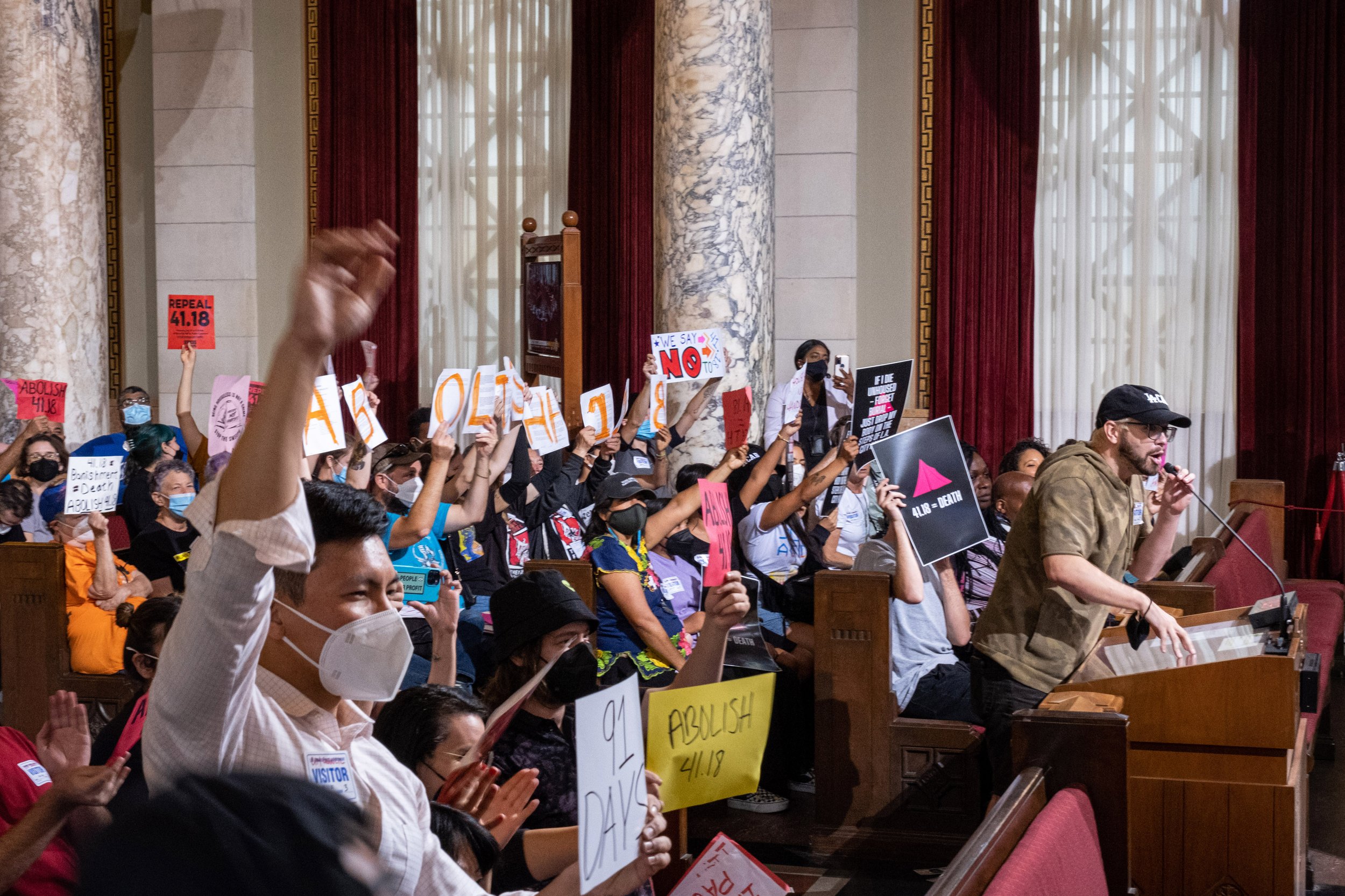  Ricci Sergienko speaks at the public hearing. The room in City Hall is filled with signs and loud tones of dissent towards the new amendment to article 41.18, which would later be passed in an 11-3 vote by the Los Angeles City Council members. The p