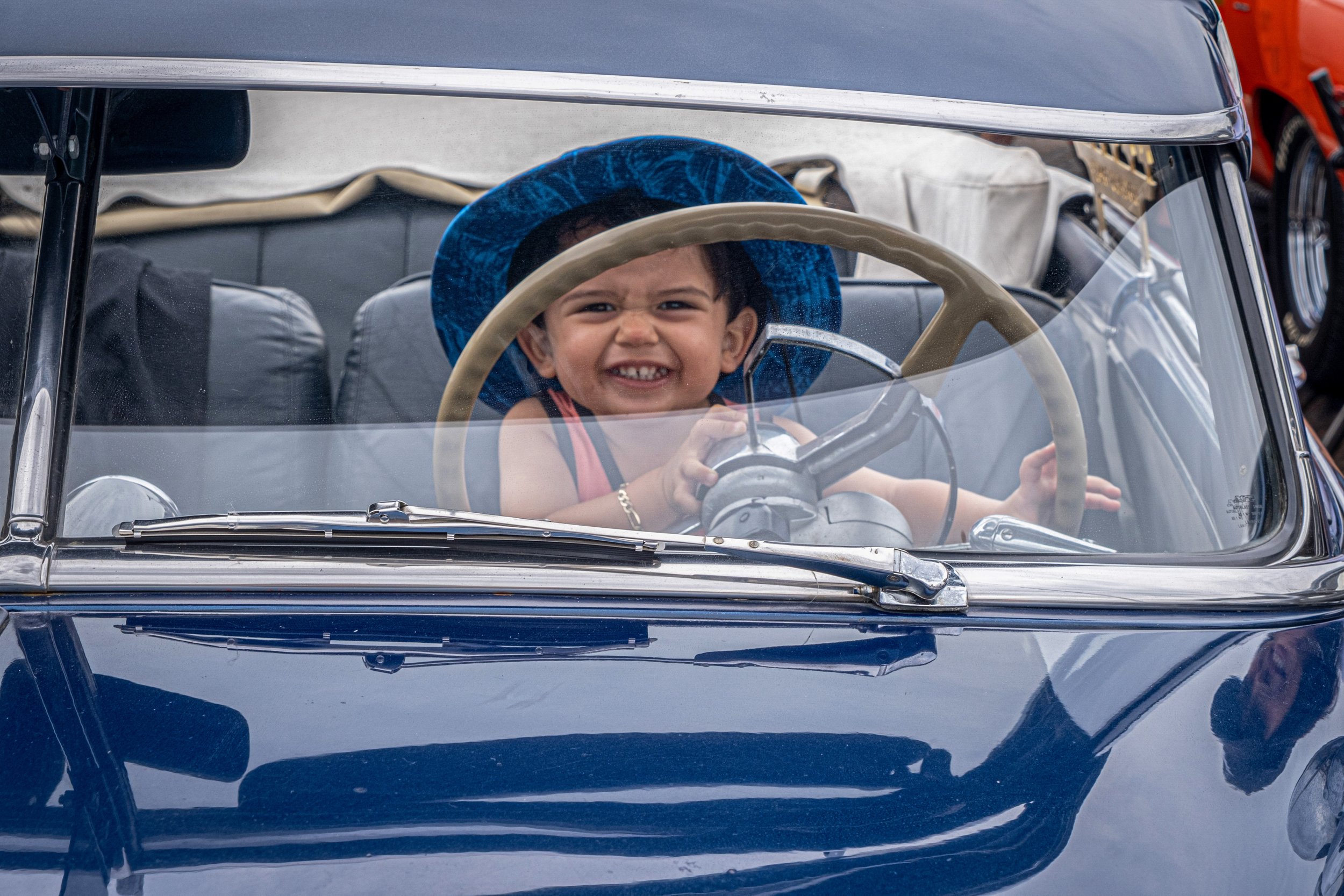  Young driver grins widely, as he takes the wheel of a classic car on Saturday. (Anna Sophia Moltke | The Corsair) 