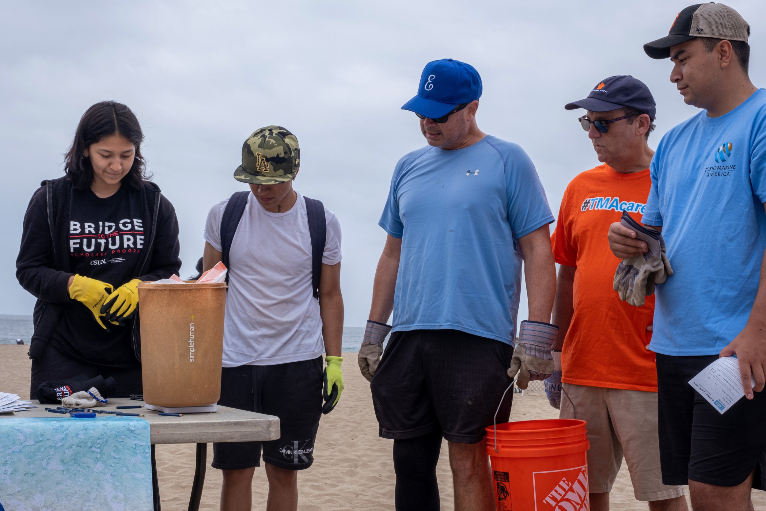  Members of Tokyo Marine LA wait to get the items they picked up from the beach weighed. The volunteer who weighs the items is from the Bridge to the Future Program.  Heal The Bay Coastal Cleanup Day in Santa Monica Calif. on Saturday, September 17, 