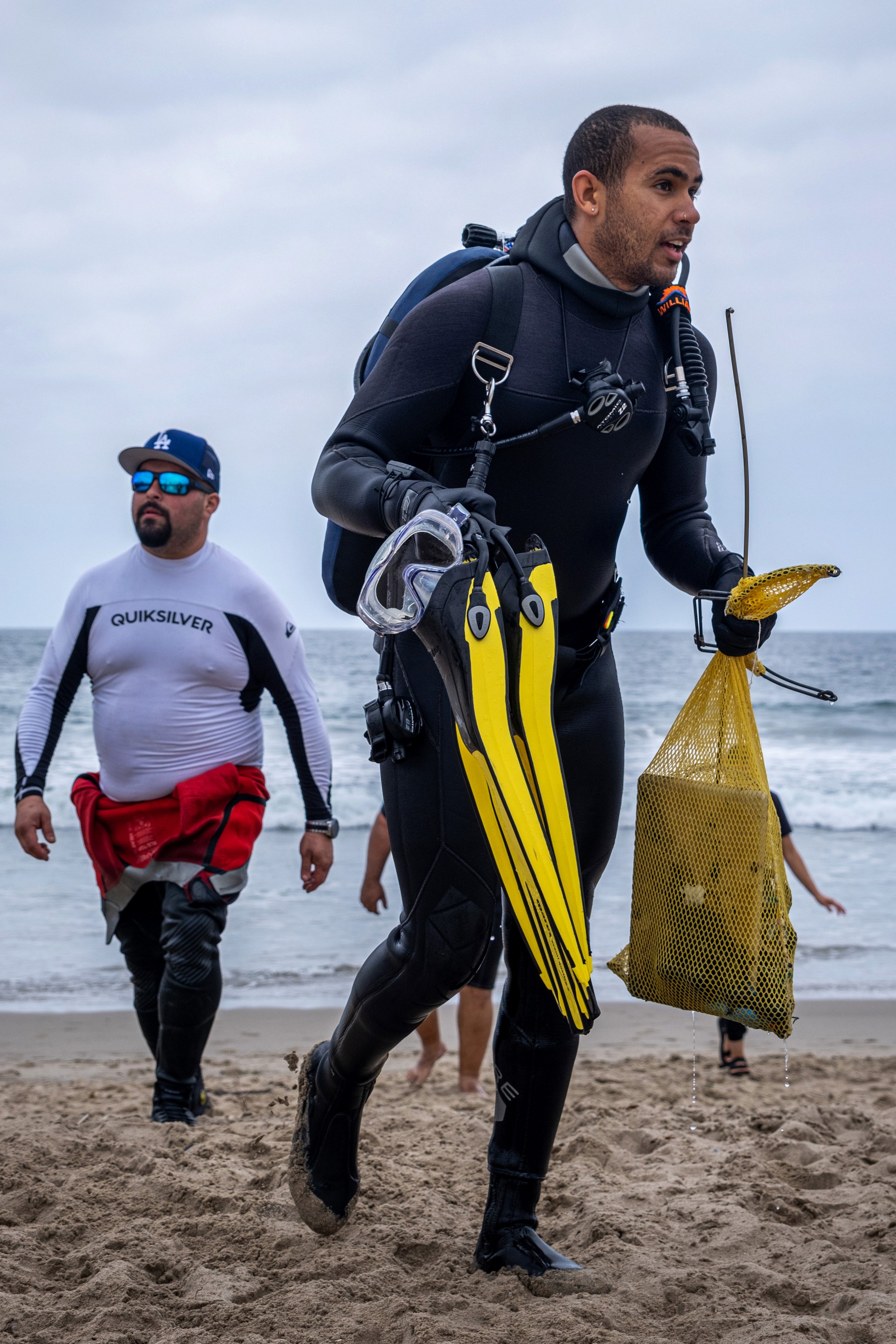  William Tobias, a member of Eco Dive Center, walks onto the shore with the trash he collected after his first dive into the ocean at Santa Monica Pier.  Coastal Cleanup Day, led by Heal The Bay in Santa Monica Calif. on Saturday, September 17, 2022.