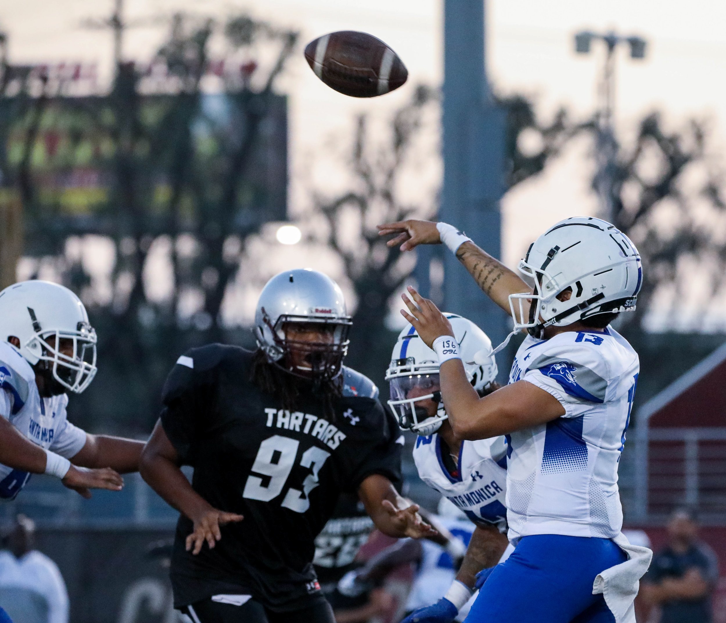  Santa Monica College Quarterback Michael Cruz (13, R) getting rid of the ball as he is rushed from oncoming Defensive player Alonzo Brand (93, L) from the Compton College Tartar rushes towards Cruz on Saturday, Sept. 17 at Compton, Calif. (Danilo Pe