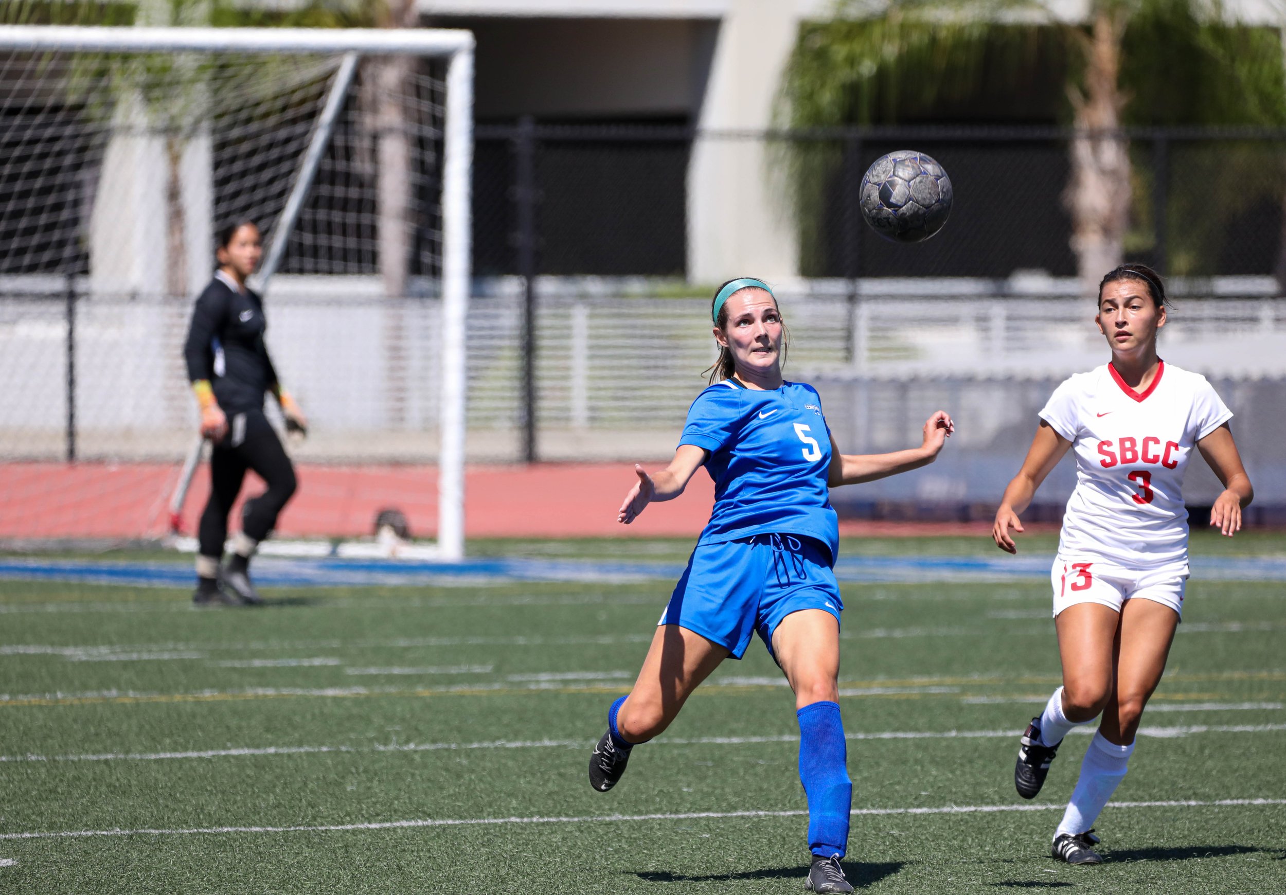  Santa Monica College(SMC) Corsairs defender Charlie Kayem (5,L) in motion to kick the ball to the opposing side to a fellow Corsair as Santa Barbra City College(SBCC) Vaqueros forward Athena Bow Graham(3,R) coming from behind trying to get possesion