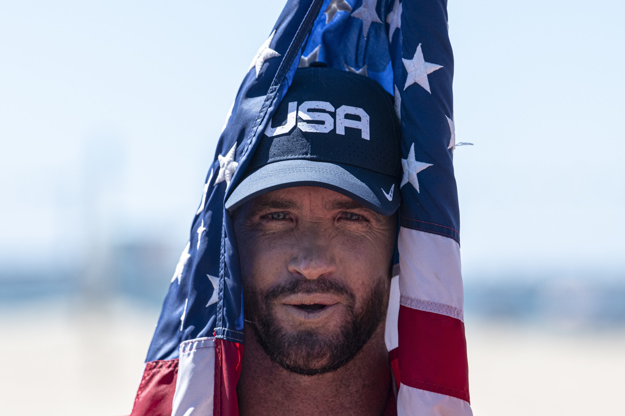 Brett Simpson from Team USA waits for the award ceremony to begin with the American flag draped over his head. (Jon Putman | The Corsair) 