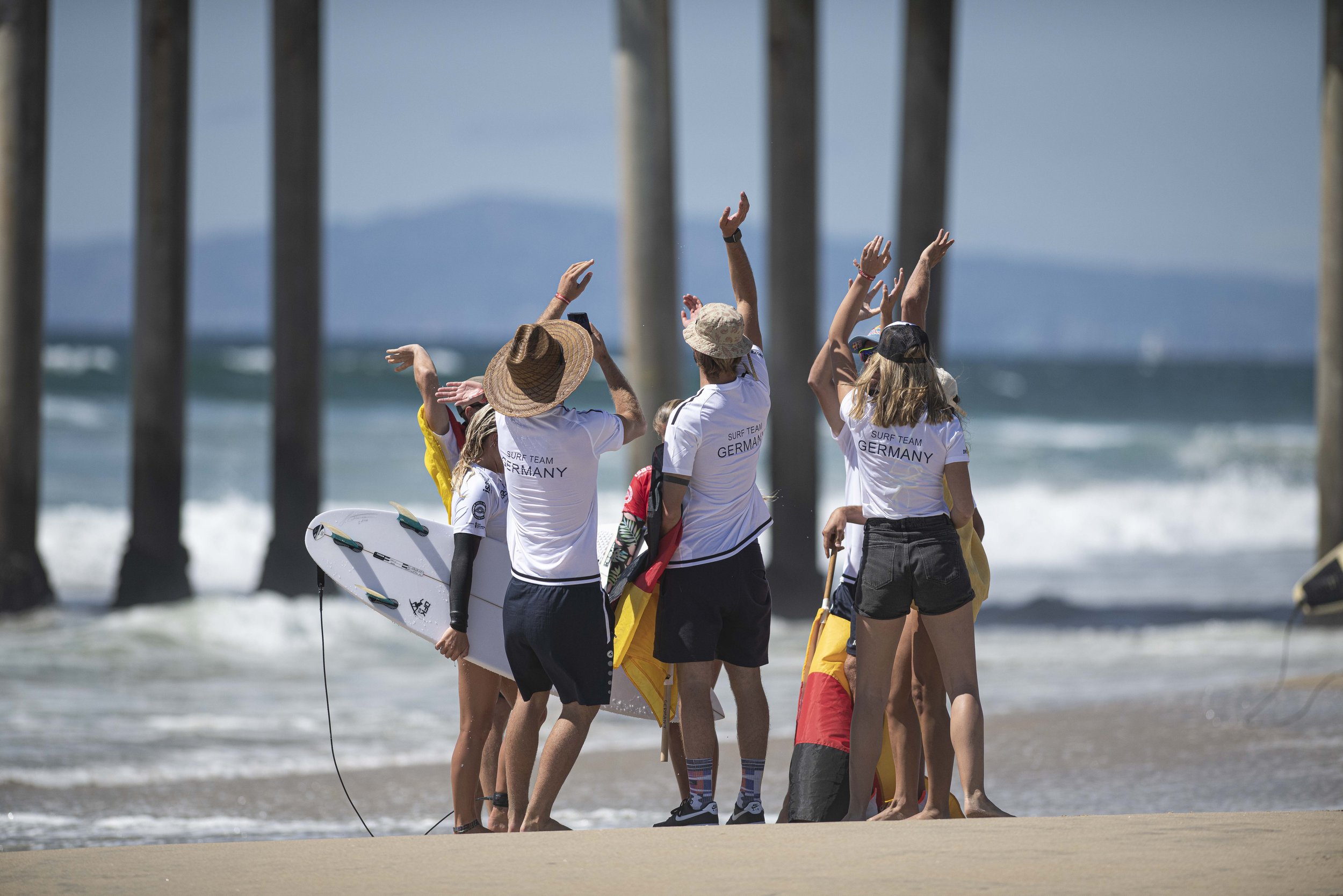  Members from team Germany break from a team huddle after sufer Rachel Presti put down her first qualification attempt. (Jon Putman | The Corsair) 