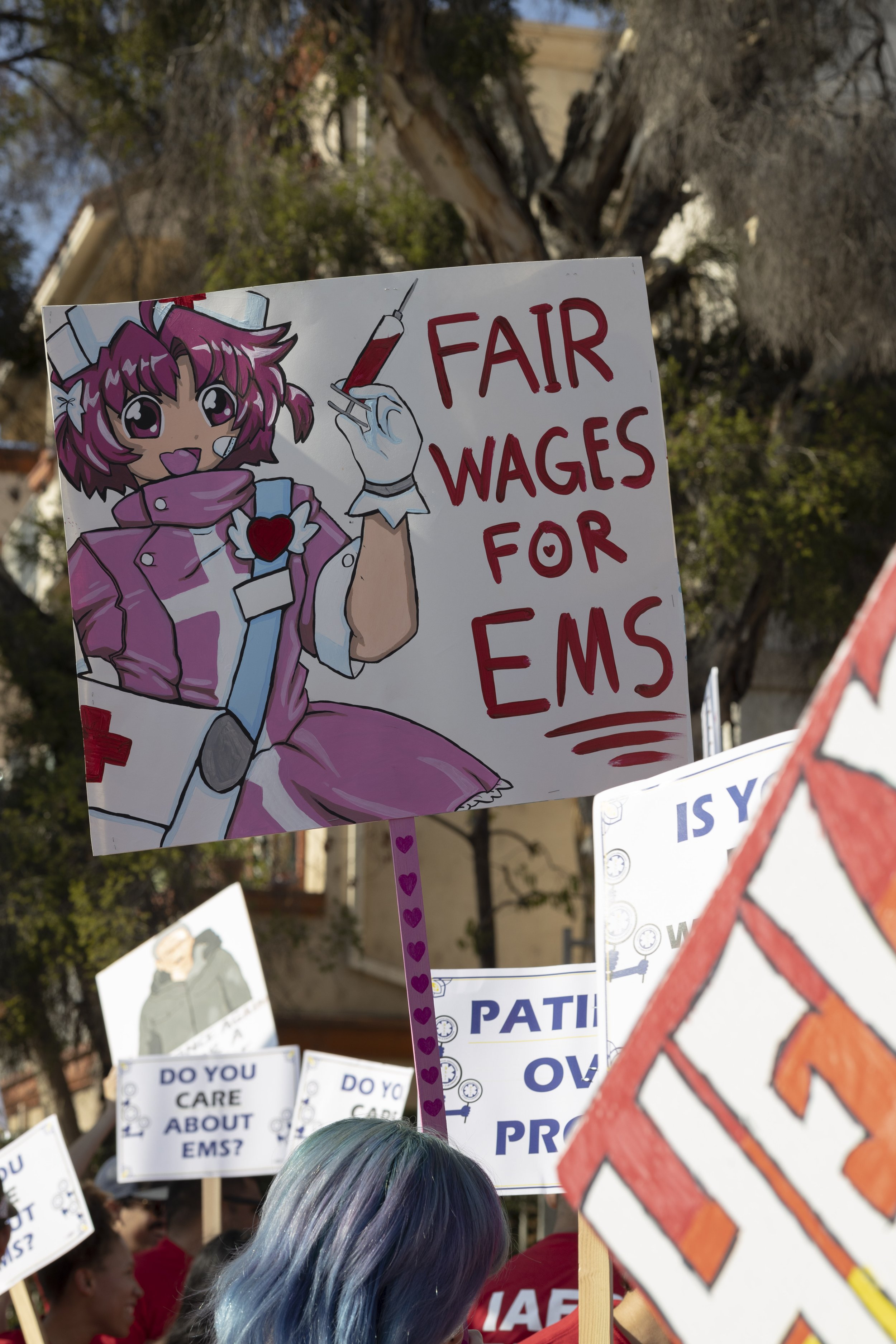  EMS workers from Los Angeles to the Antelope Valley holding their home made signs up for people honking their horns in solidarity to their march for fair wages in downtown Los Angeles. East Los Angeles, Calif. September 13, 2022. (Jamie Addison|The 