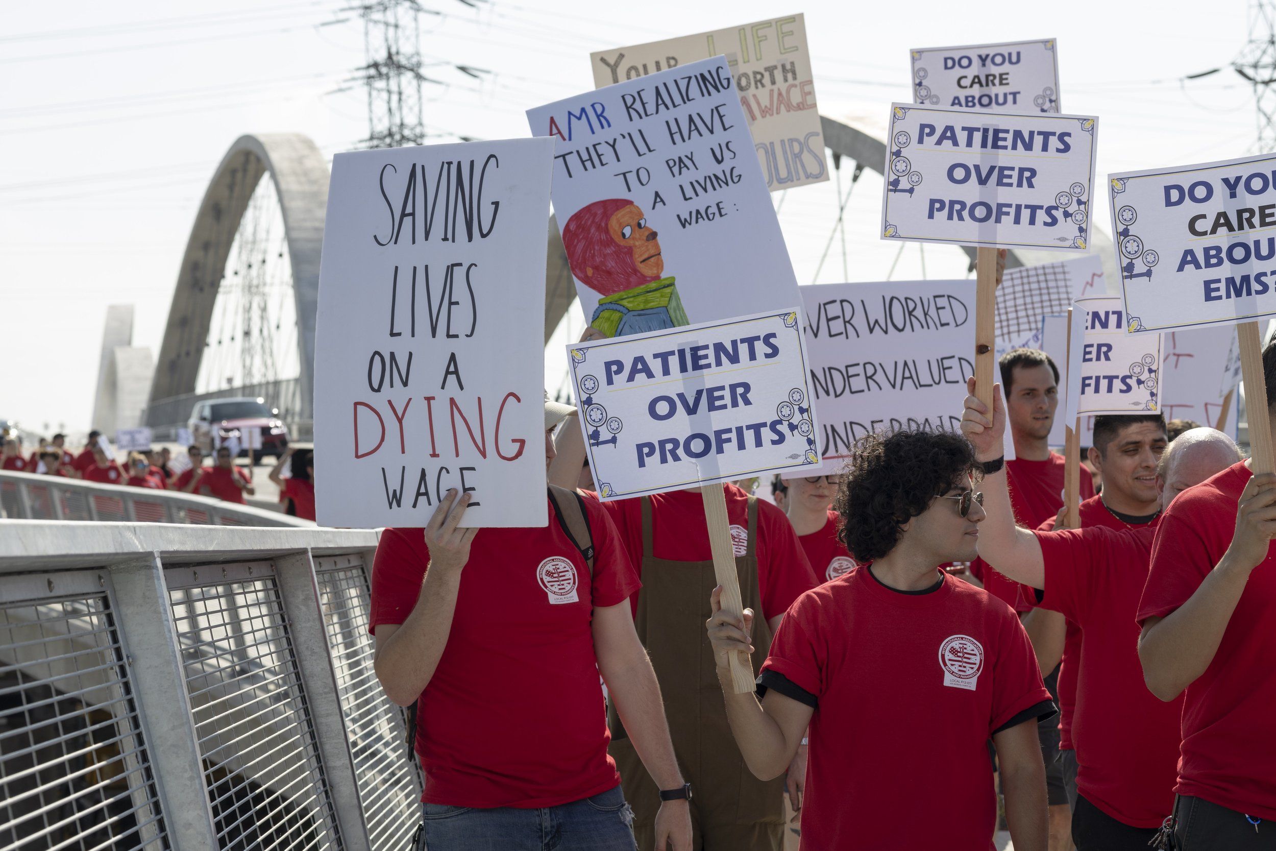  EMS workers from Los Angeles to the Antelope Valley marching over the sixth street bridge into downtown Los Angeles with their signs and red shirts for the march for fair wages. American Medical Response has told the workers they have given their "l