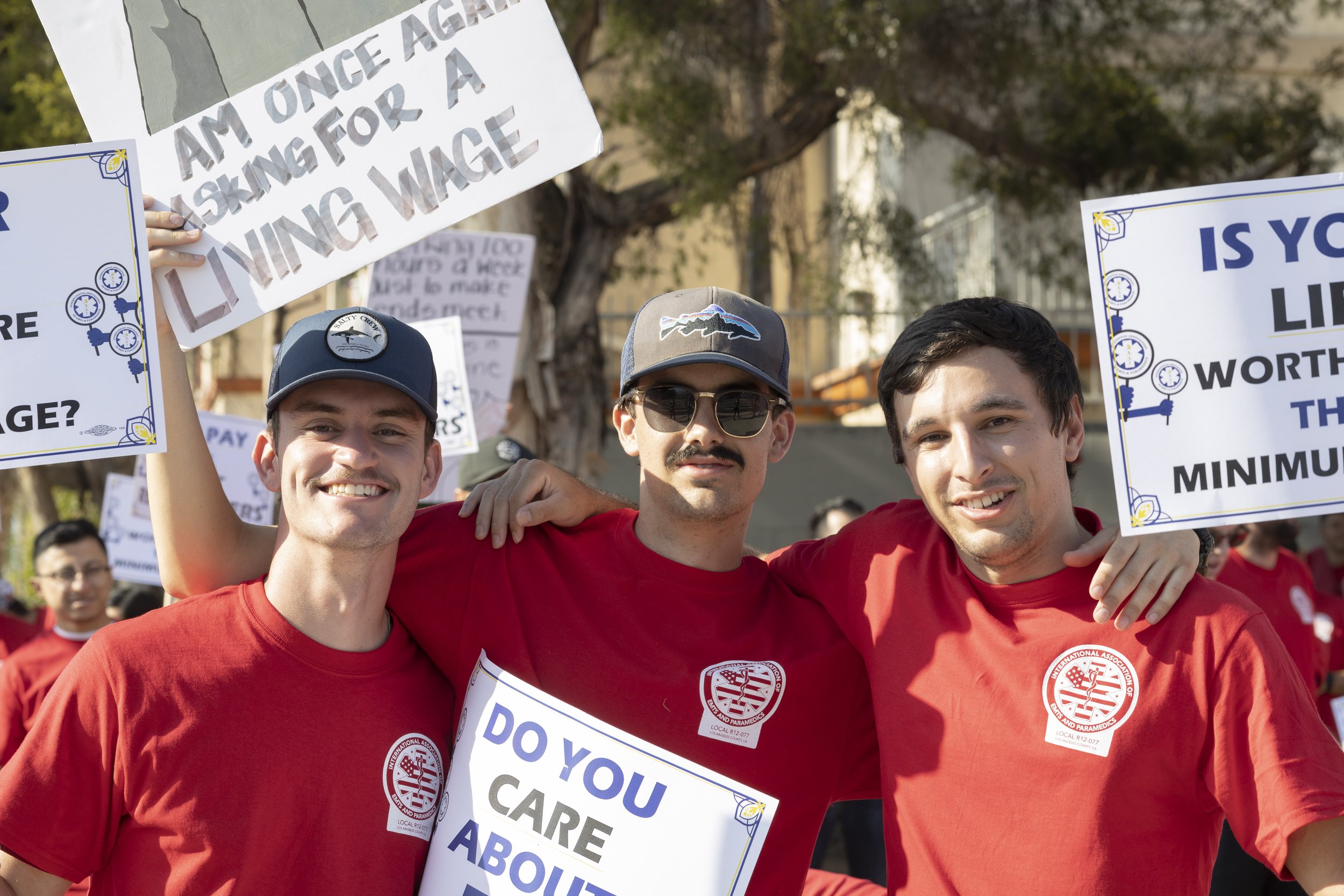  Josh Lebman (left), Zackary Silgero (middle) and Scott Masson (right) may look happy in this photo, but they stated that they are "pissed off and tired" of fighting for fair wages for a job that saves lives daily. Before the march, EMS workers congr