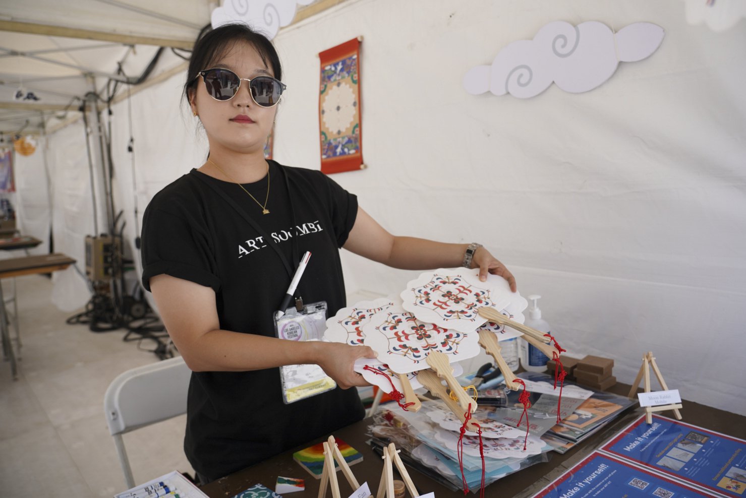  A shopkeeper poses for a portrait displaying handmade korean fans during the 49th annual Los Angeles Korean Festival Friday, September 23 2022 at the Seoul International Park. The 49th incarnation marks the return of the in-person festival following