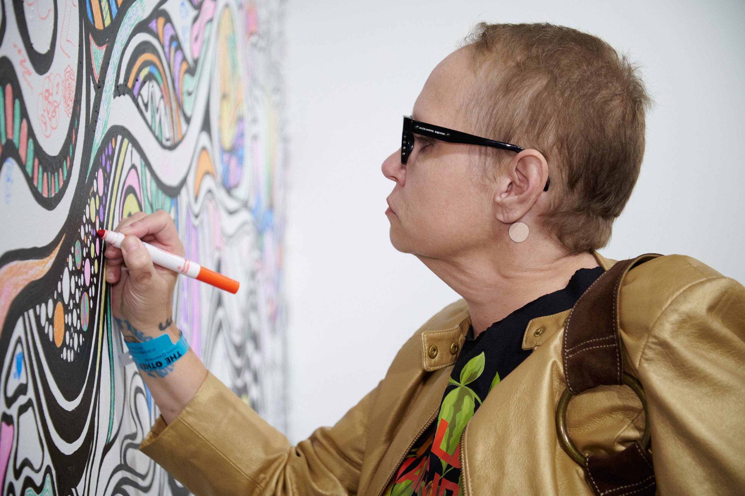  Attendee Elissa Rosen draws on artist Kelsey Griffen's "Interactive Mural" at The Other Art Fair on Thursday, Sept. 22, 2022, at The Barker Hangar in Santa Monica, Calif. (Nicholas McCall | The Corsair) 