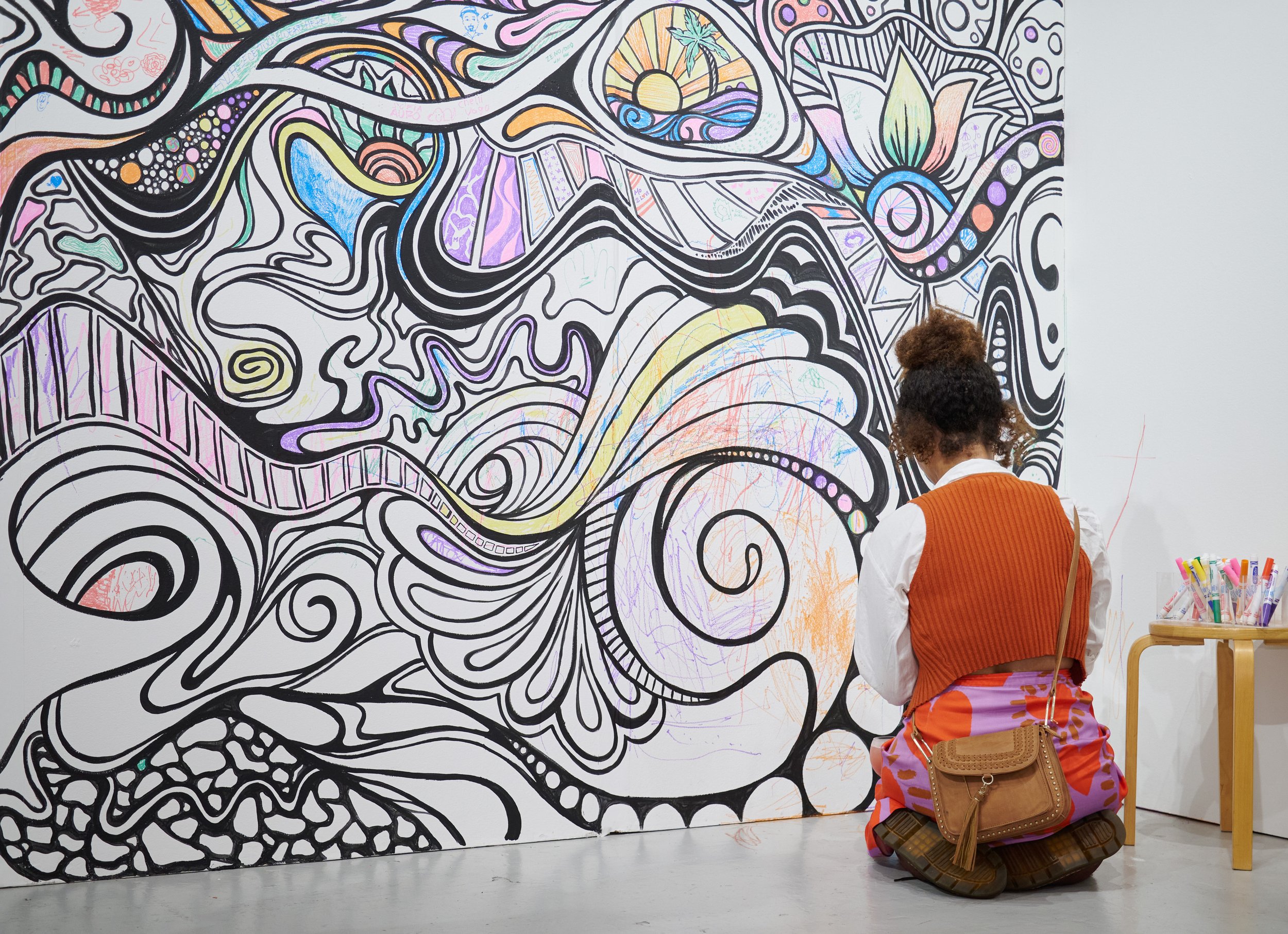  Attendee Anika Ajaga draws on artist Kelsey Griffen's "Interactive Mural" at The Other Art Fair on Thursday, Sept. 22, 2022, at The Barker Hangar in Santa Monica, Calif. (Nicholas McCall | The Corsair) 