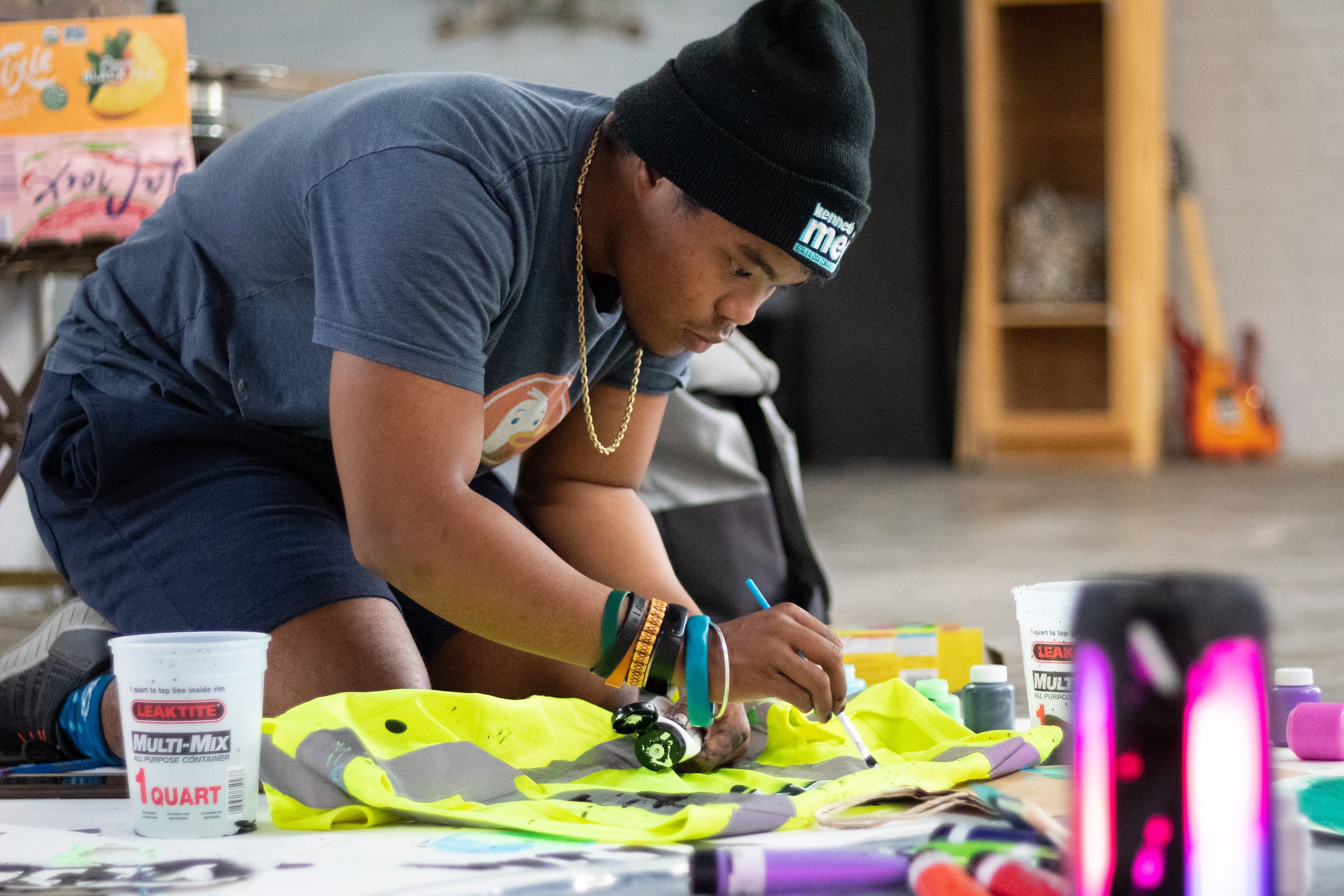  Sim Bilal painting YCSLA (Youth Climate Strike Los Angeles) onto a high visibility jacket, during a sign making event, for the Youth Climate Strike at the Los Angeles City Hall the next day. Sim is the main organizor and director for the Youth Clima