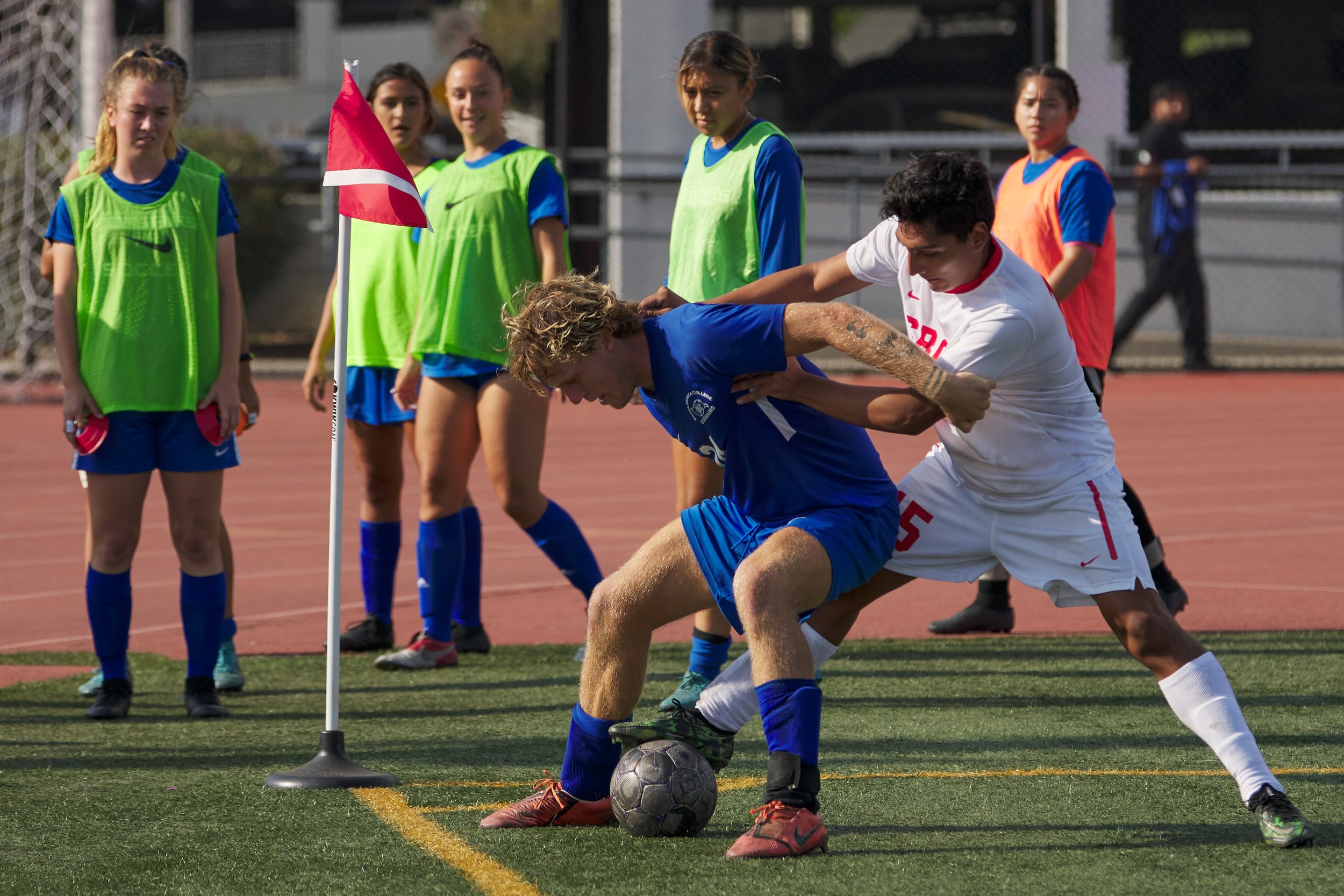  Members of the Santa Monica College Corsairs Women's Soccer team pause to watch Santa Barbara City College Vaqueros' Jahir Valdez (right) steal the ball from fellow Corsair Alexander Lalor (center) during the men's soccer match on Tuesday, October 1