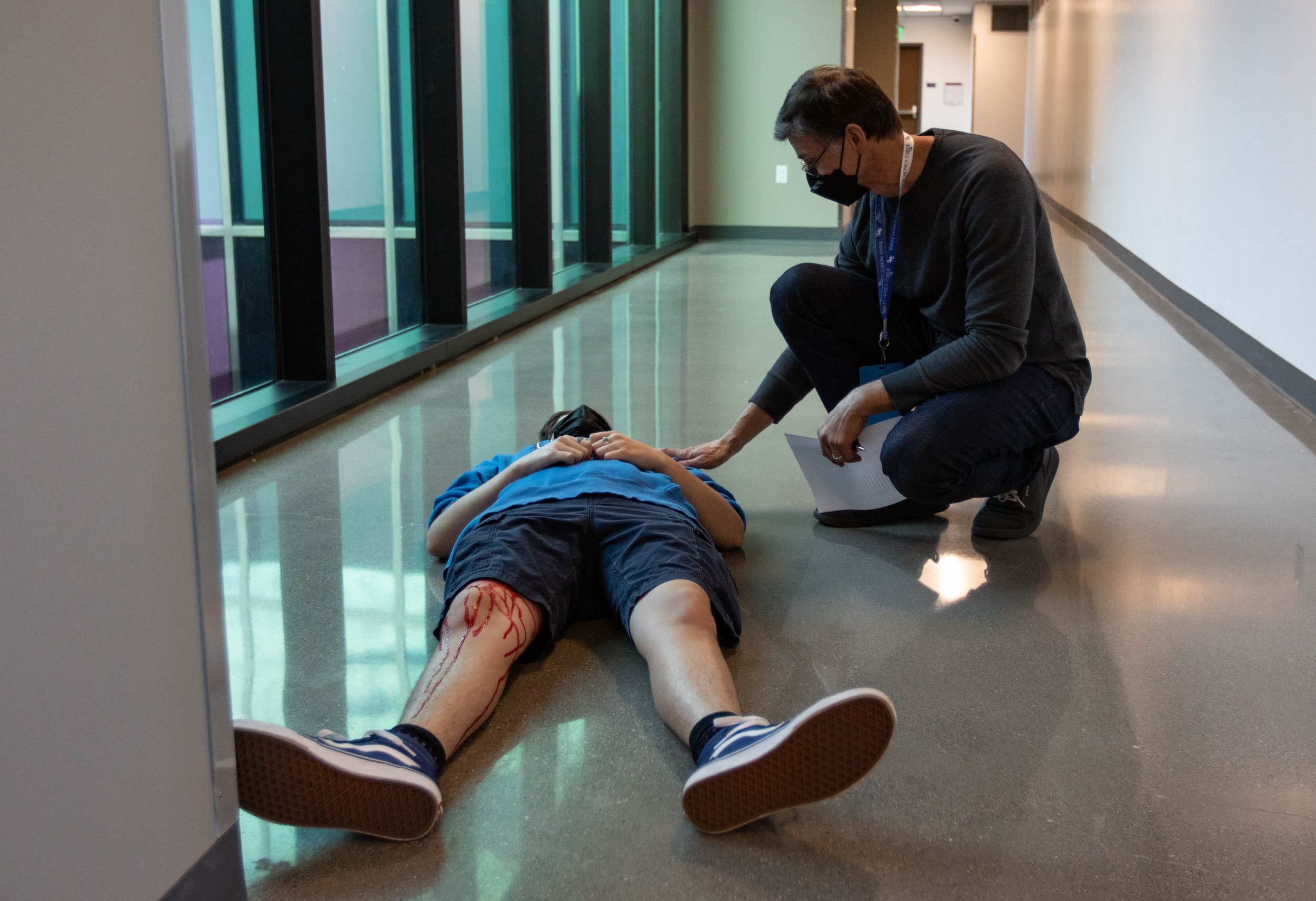  Pressian Nicolov, Santa Monica College (SMC) International Student Center faculty member checks on Alex Bonin, one of the simulated  injury drill participants at the second floor of the Student Services Center during the 2022 Great ShakeOut SoCal Ea