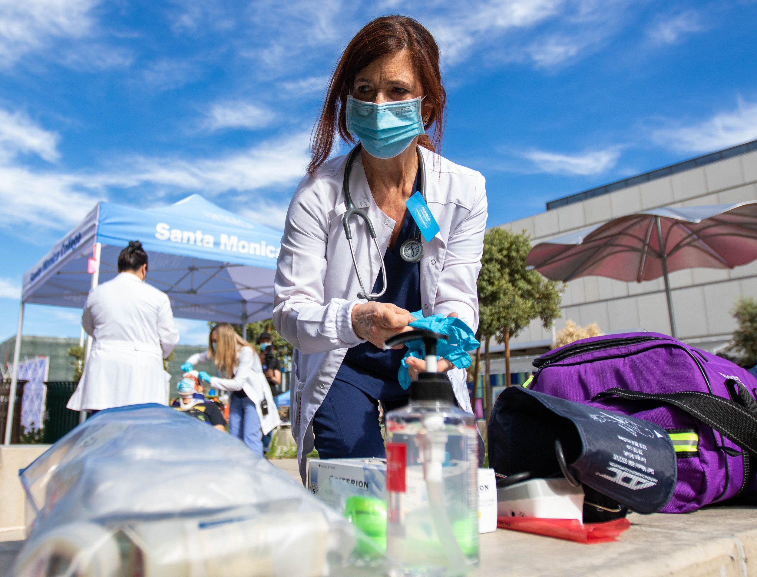  Santa Monica College (SMC) Nurse Practioner Maria Arango rushes to grab a pair of gloves as student Daniel Torres receives medical attention outside the SMC Student Services Center. Torres is one of the simulated injured drill participant for the 20