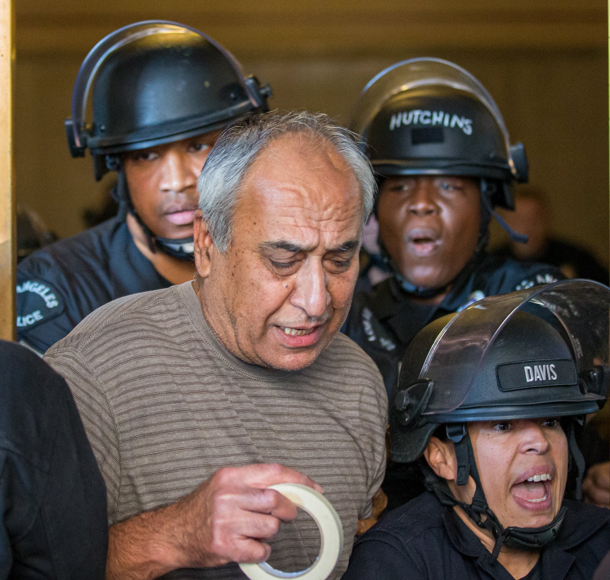  Hamid Kan being pushed out the Los Angeles City Hall by LAPD wearing riot gear as protesters made their way inside taping up flyers calling for the resignation of Kevin De Len on Tuesday, Oct. 18 after racist remarks were made in a leaked audio at L