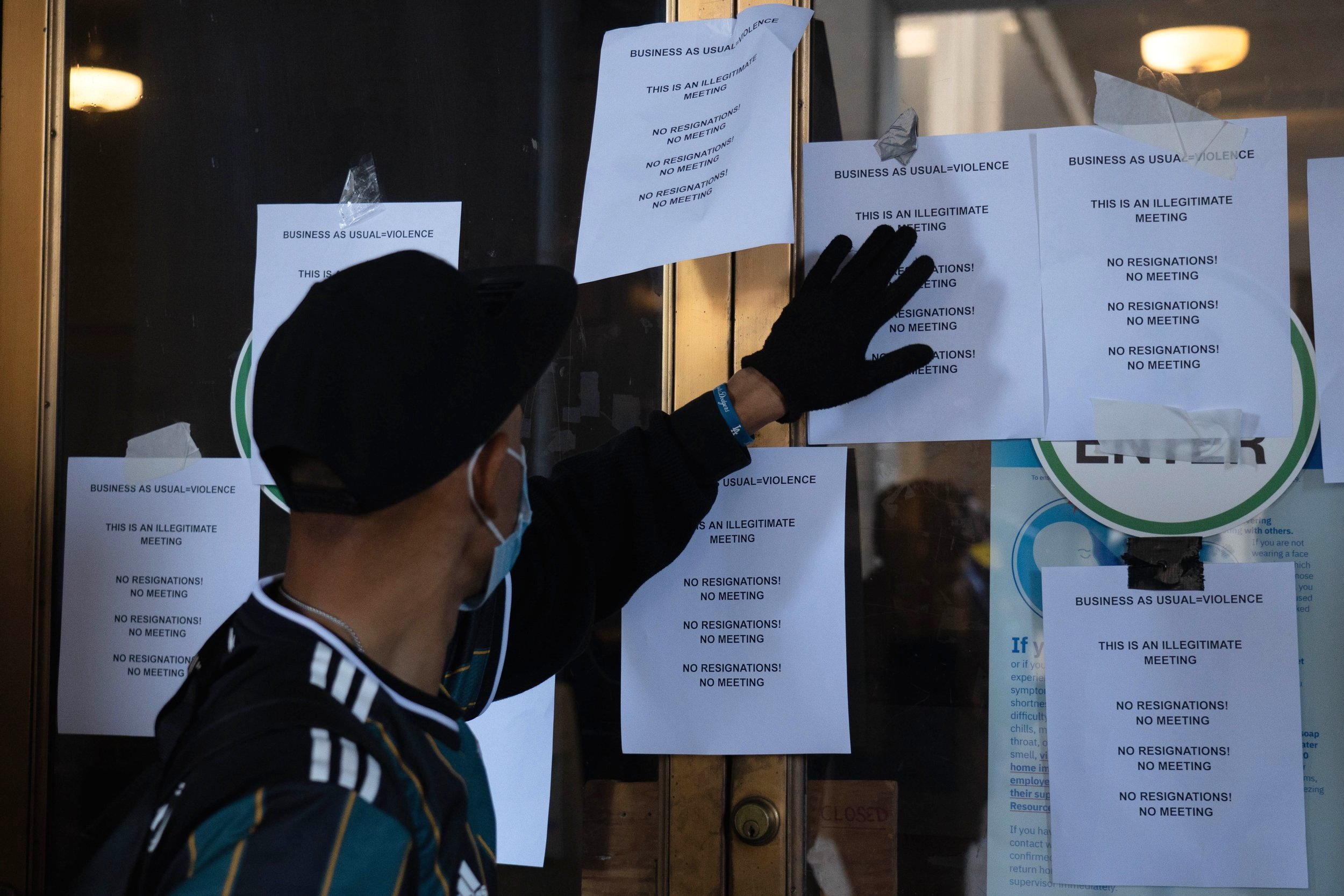  A demonstrator posts homemade flyers at the entrance of Los Angeles City Hall during a protest against the City Council Tuesday, Oct 18 2022. Multiple activist organizations are demanding the resignation of council members caught making racially cha