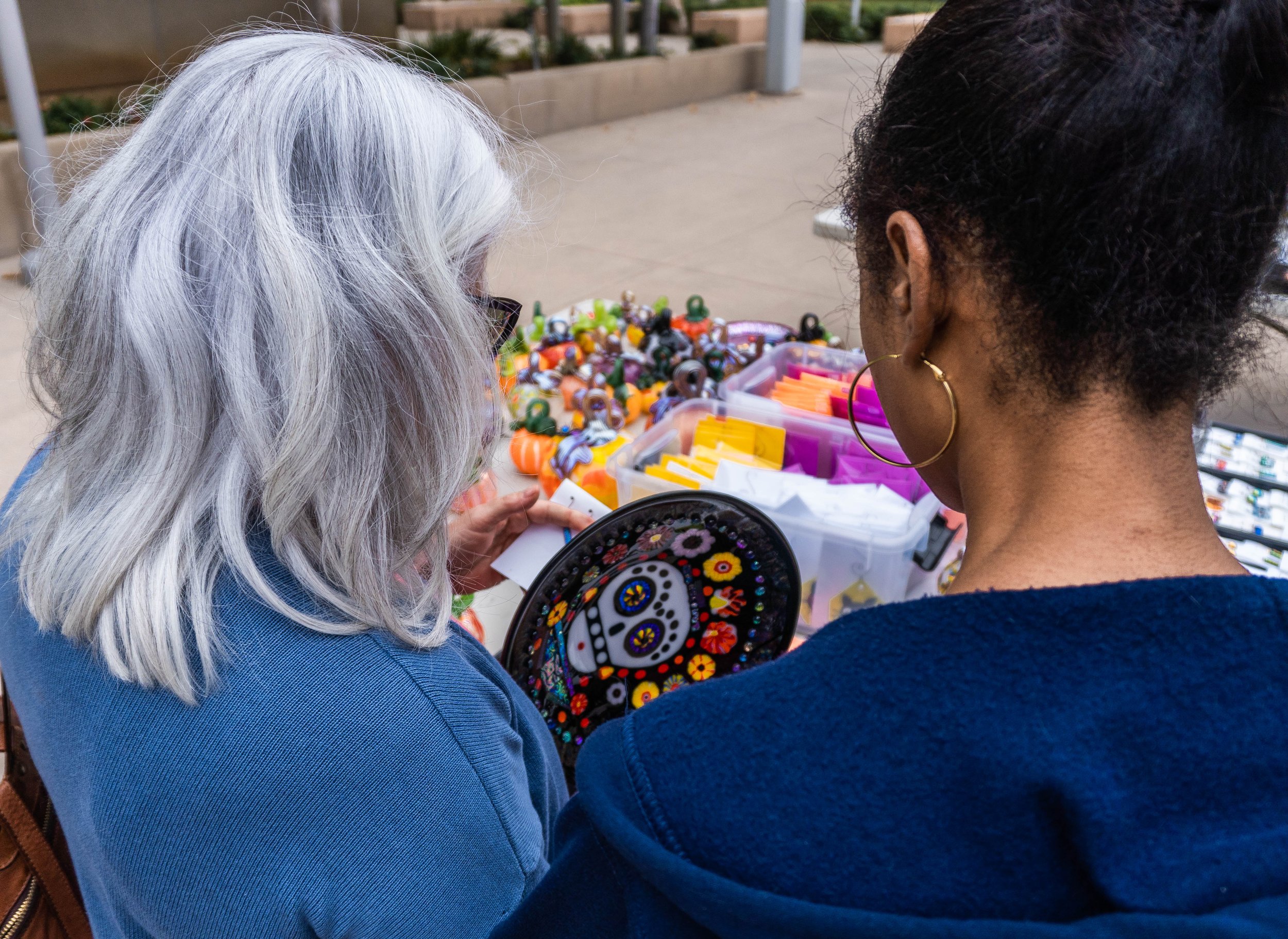  Anisha DiGregorio, Santa Monica College (SMC) Human Resource staff and Susan Caggiano, a faculty member of the English department look at a handmade plate for sale at the SMC Art Department's annual Glass Pumpkin Sales. DiGregorio has been coming to