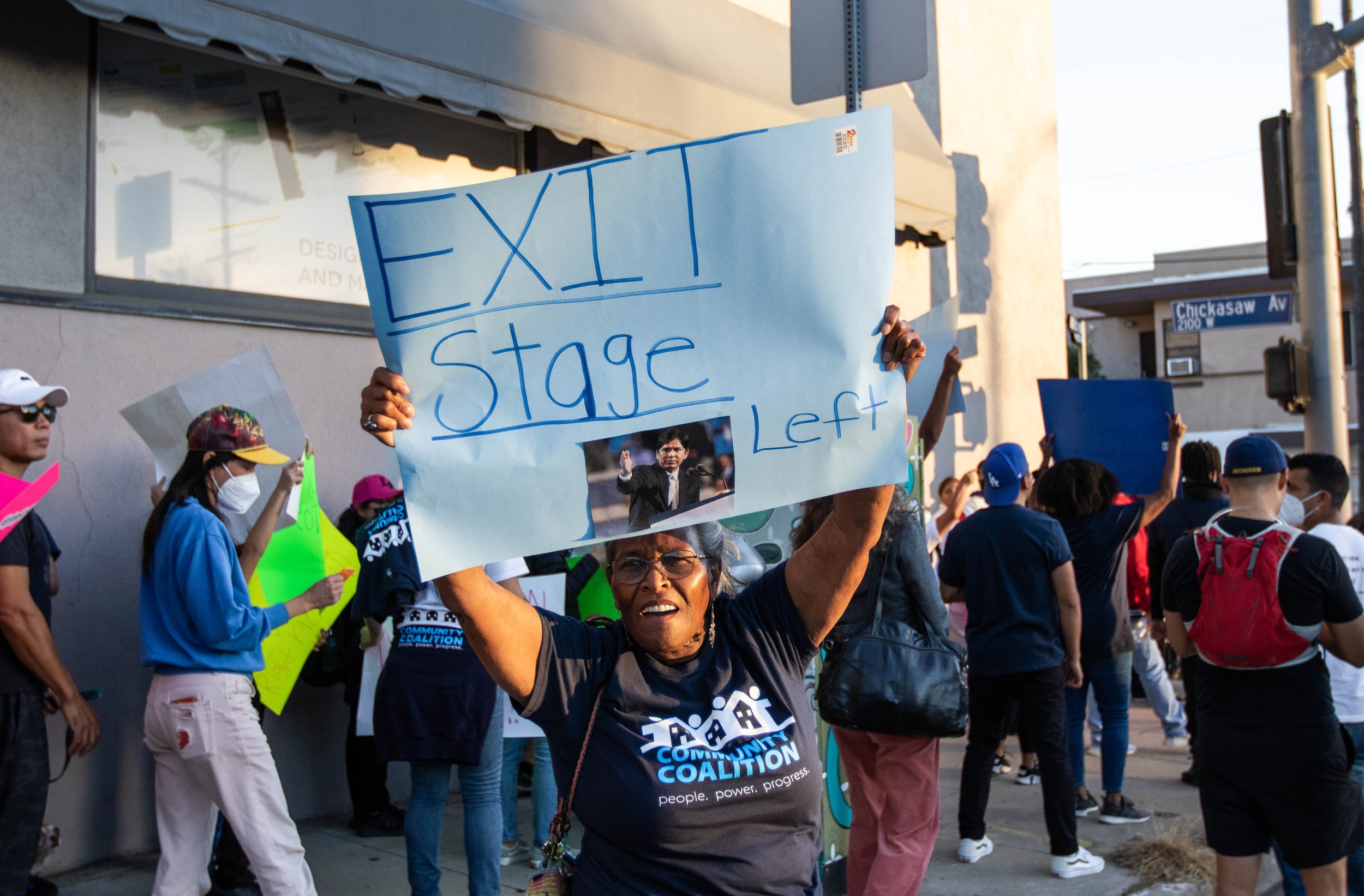  (L) Maria Isabel Rutledge holds a sign demanding León to "exit stage left", in response to the leaked audio tapes in Los Angeles City Hall, consisting of racist remarks from León and other LA council members. On Oct. 24, 2022, a rally of approximate