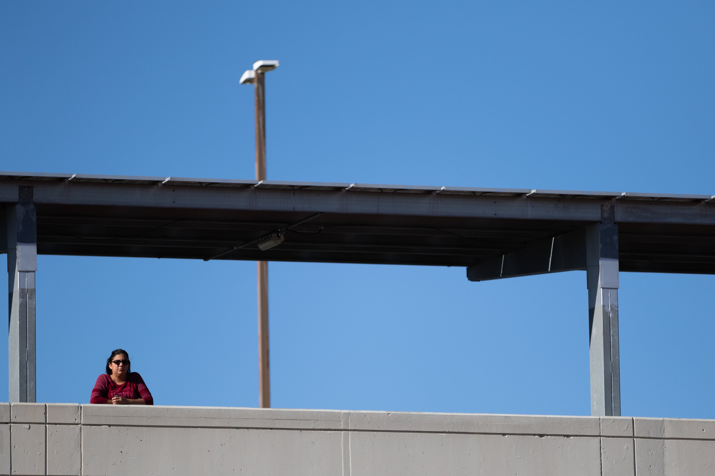  A person watching a football game between Santa Monica College Corsairs and Santa Barbara City College Vanqueros atop the parking garage during a recent home game on Saturday, Nov. 12, 2022, at Santa Monica College, Santa Monica, Calif. The game end