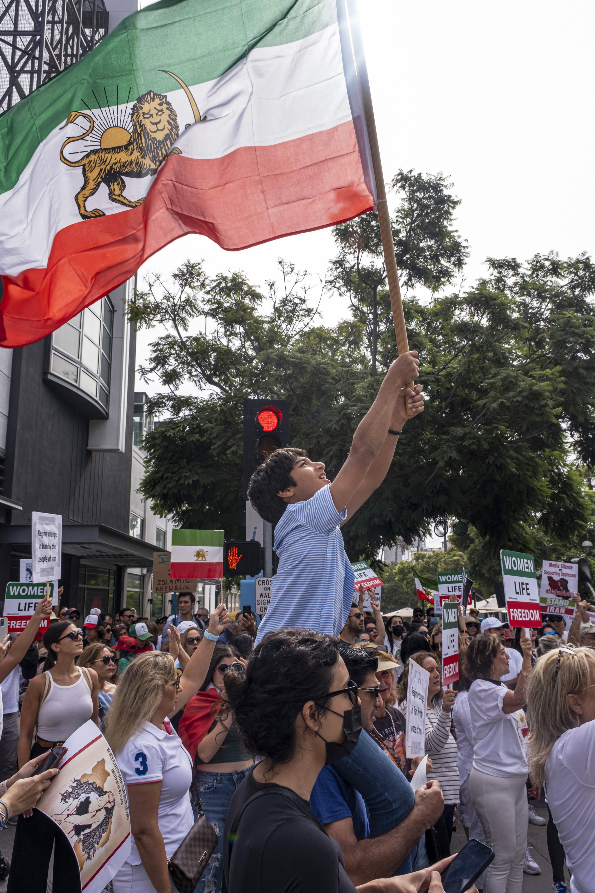  A father holds his son on his shoulders, and the boy looks up at the flag that he is holding. March for Iran, at Third Street Promenade in Santa Monica, Calif., on Saturday, Oct. 8. (Anna Sophia Moltke | The Corsair) 