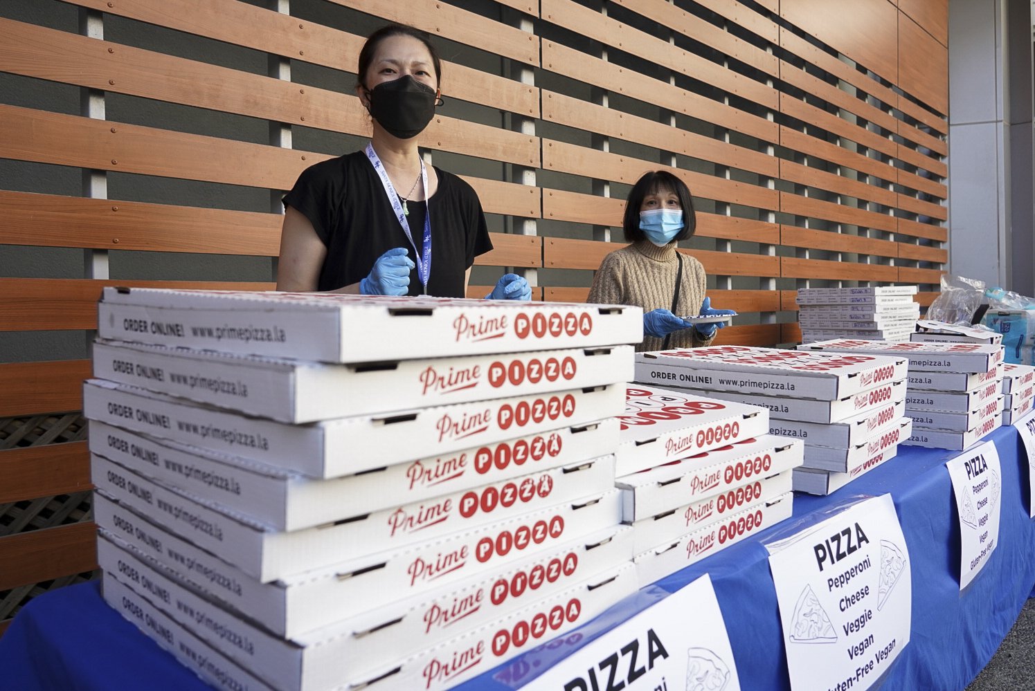  Lin-San Chou (left) distributes complementary pizza during an open house hosted by the faculty of the Santa Monica College Music Department Tuesday, Nov. 15 2022. 