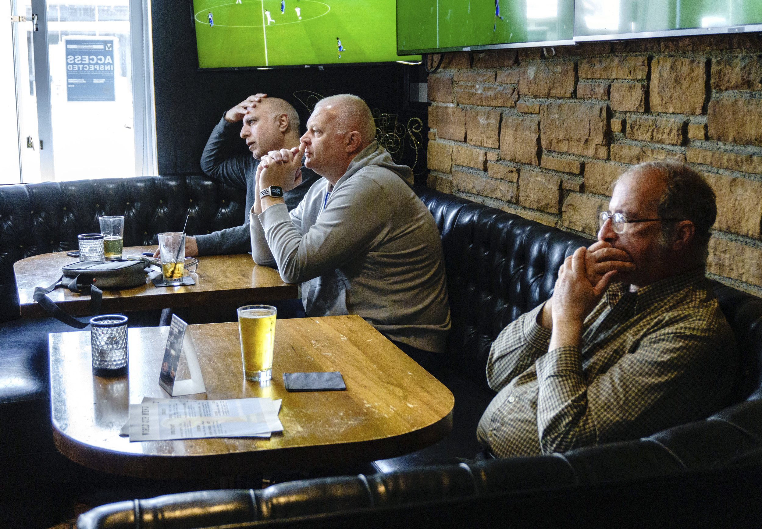  (L-R) David Massey, Stephan Ruers and Dov anticipatedly watch the USA soccer team play Iran in the FIFA World Cup Qatar 2022 at Busby's West sports bar and restaurant in Santa Monica. Massey is oringinally from England but is supporting the USA team