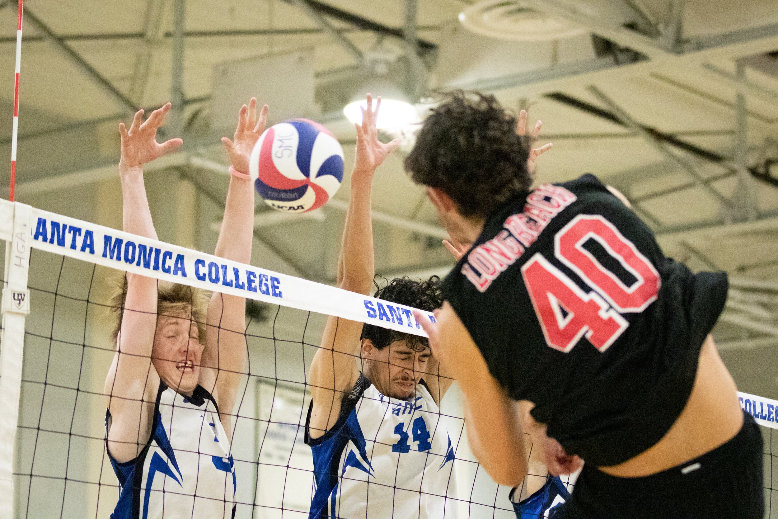  Santa Monica College Corsair setter Camden Higbee (3, left) and opposite Luis Garzon (14, center) attempting to block a spike by Long Beach City College Viking Matthew Pennala (40, right) during the first set of a home game in Santa Monica, Calif., 