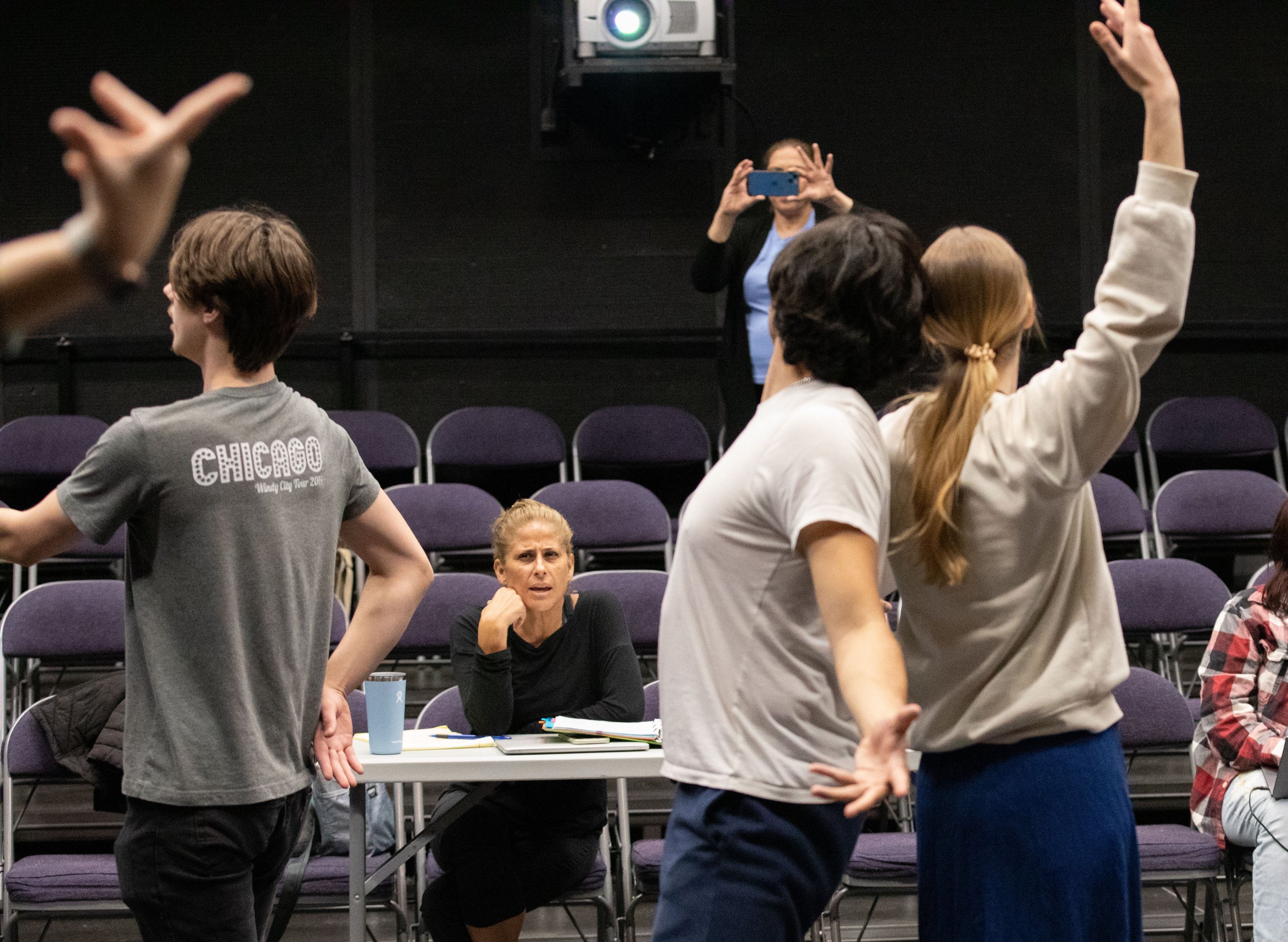  SMC Theater students Kathy Syta and Steve Whittle stand back to back at the end of their routine. In front, choreographer Cihtli Ocampo and Instructor Perviz Sawoski videoing with her phone from the top during class rehearsal for the musical “Hunchb