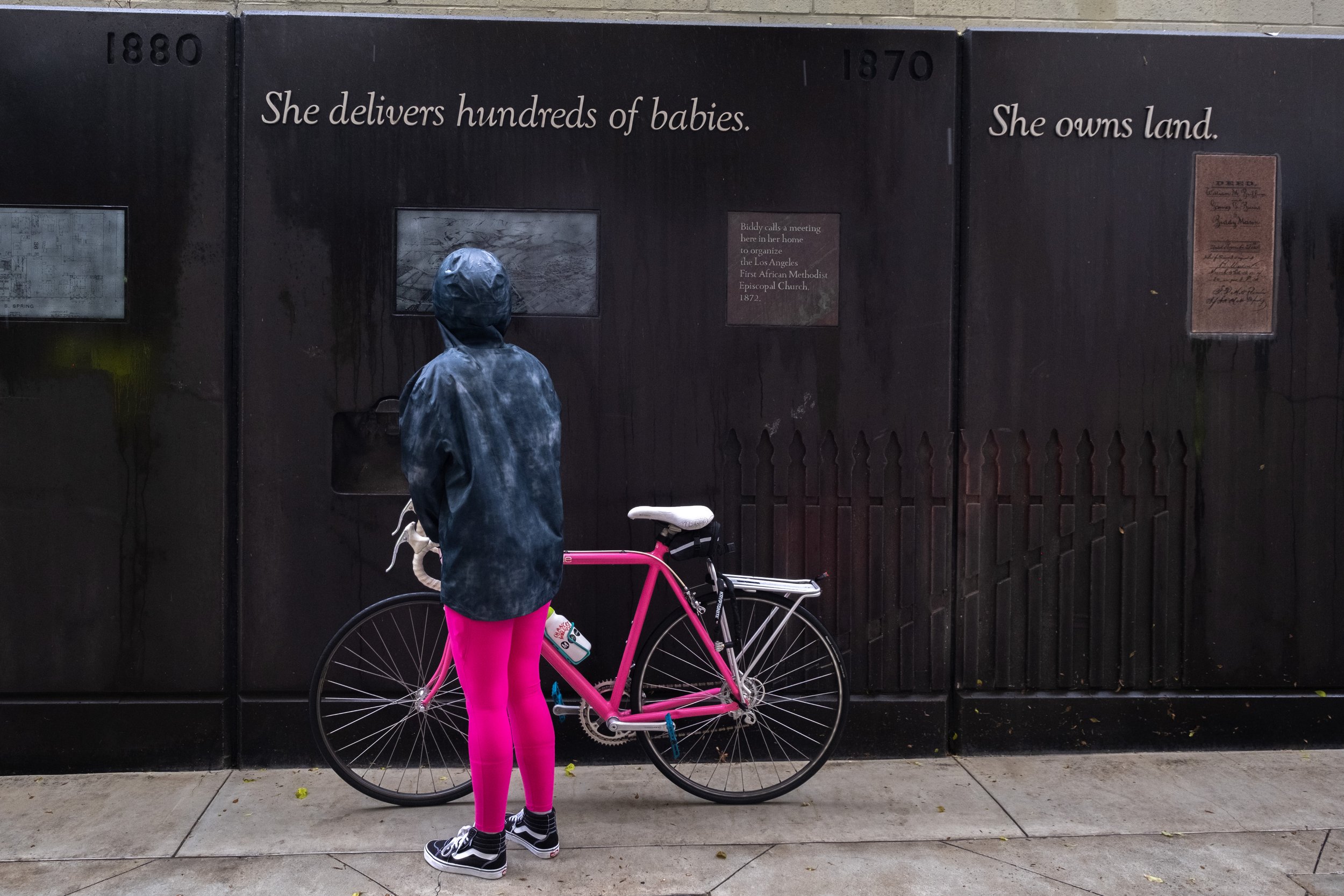  A biker on the Metro Bike Share Women's History Community Ride stops to read the captions on the exhibit featuring Biddy Mason at the Biddy Mason Memorial Park in Downtown Los Angeles, Calif. on Saturday, March 11, 2023. (Akemi Rico | The Corsair) 