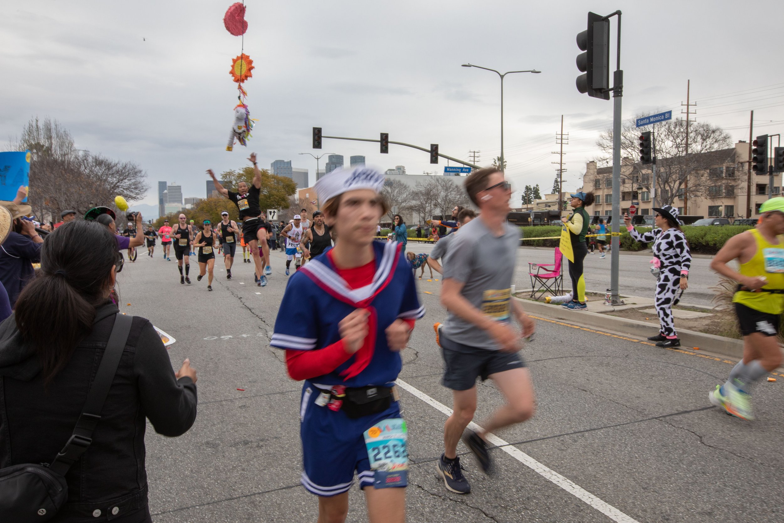  Valley Runners Los Angeles member Anthony Hartzog jumps to the piñata. He makes it to mile 19 where his club cheers him up. At the same time Hartzog requires helps with a cramp from the cheering station during the 38th Annual L.A. Marathon 2023. Sun