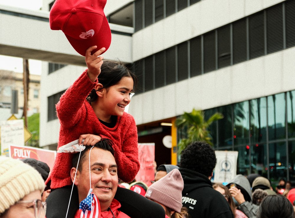  Manny Banuelos carrying his daughter Isabella at the United Teachers Los Angeles rally in support of the teachers demanding better benefits and an increase in wage outside the LA Unified School District on Tue. March 21 at Los Angeles, Calif. (Danil