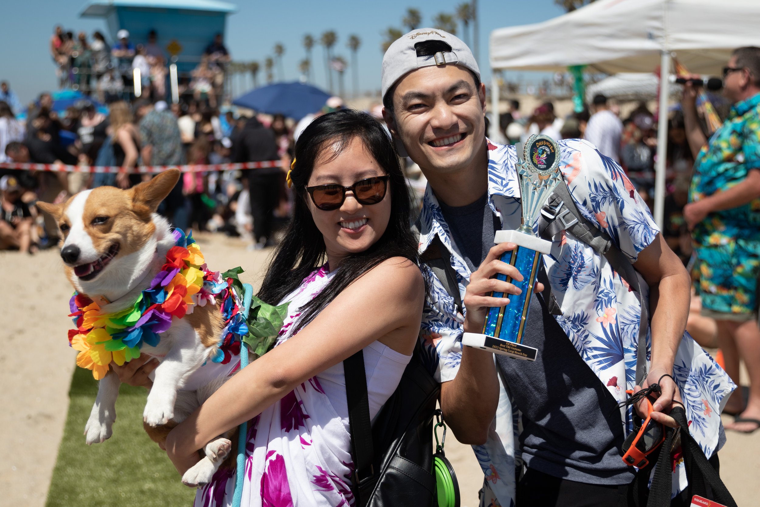  Haley (L-R) and her owners, Kimmie Le and Lam Tran, after winning the tiki theme section of the Best Corgi Costume Contest during Corgi Beach Day at Huntington Dog Beach, Huntington Beach, Calif., on Saturday, April 1, 2023. There were over a thousa