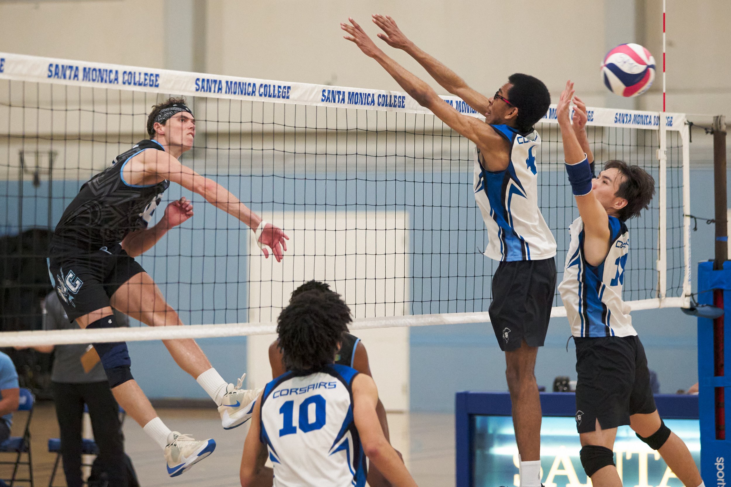  Moorpark College Raiders' Sean Schmutz hits the ball past Santa Monica College Corsairs' Beikwaw Yankey and Enkhtur Tserendavaa during the men's volleyball match on Wednesday, April 12, 2023, at Corsair Gym in Santa Monica, Calif. The Corsairs lost 